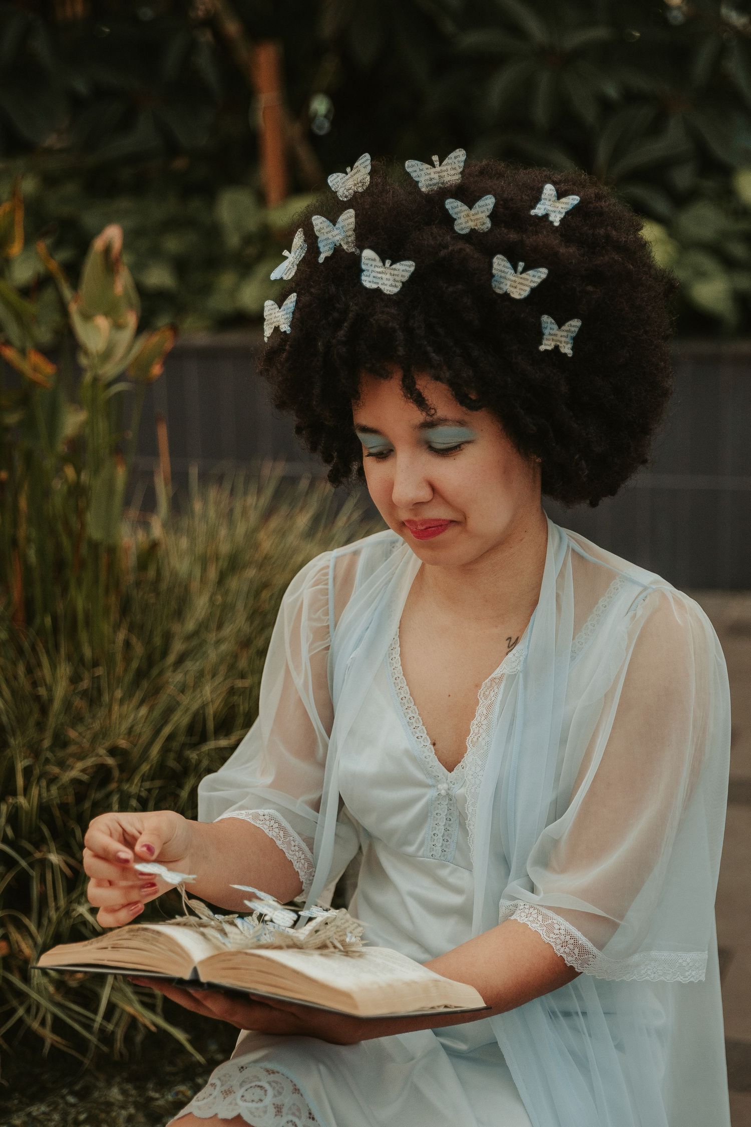Whimsical garden scene with white butterflies and an open book.