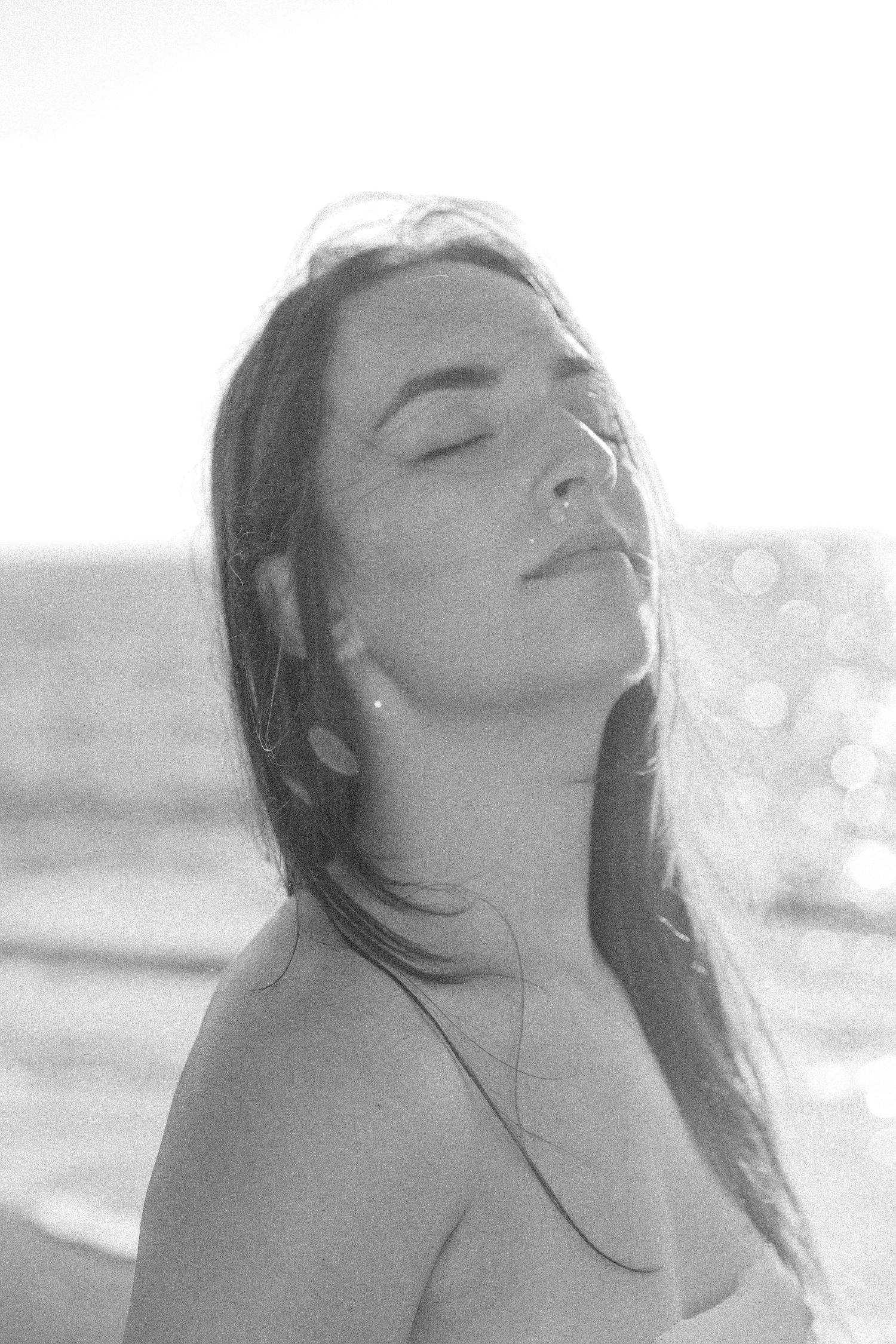 Artistic black and white beach portraits with dramatic lighting and ocean spray.