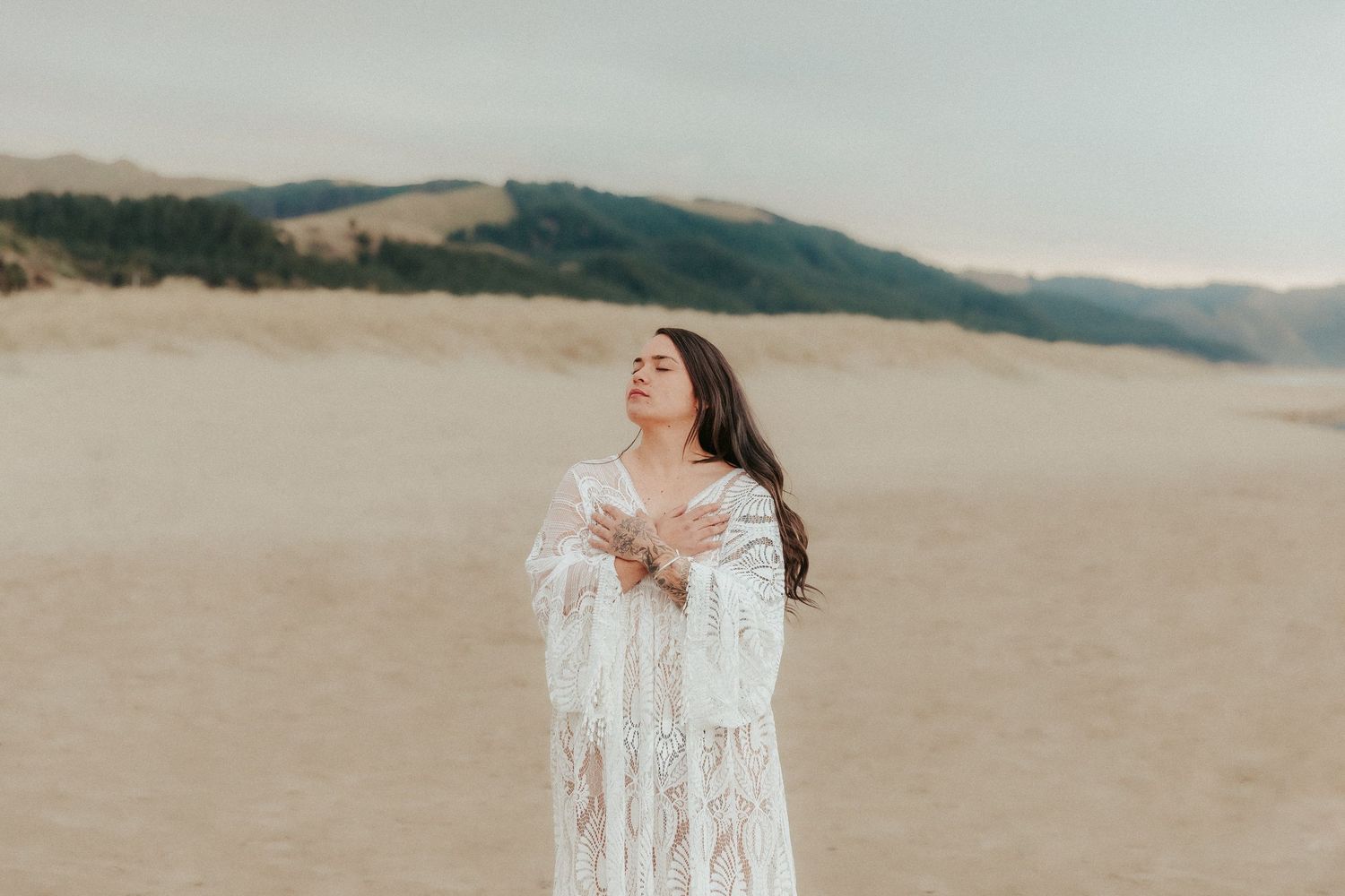 Whimsical beach photography featuring flowing white dress and coastal scenery.