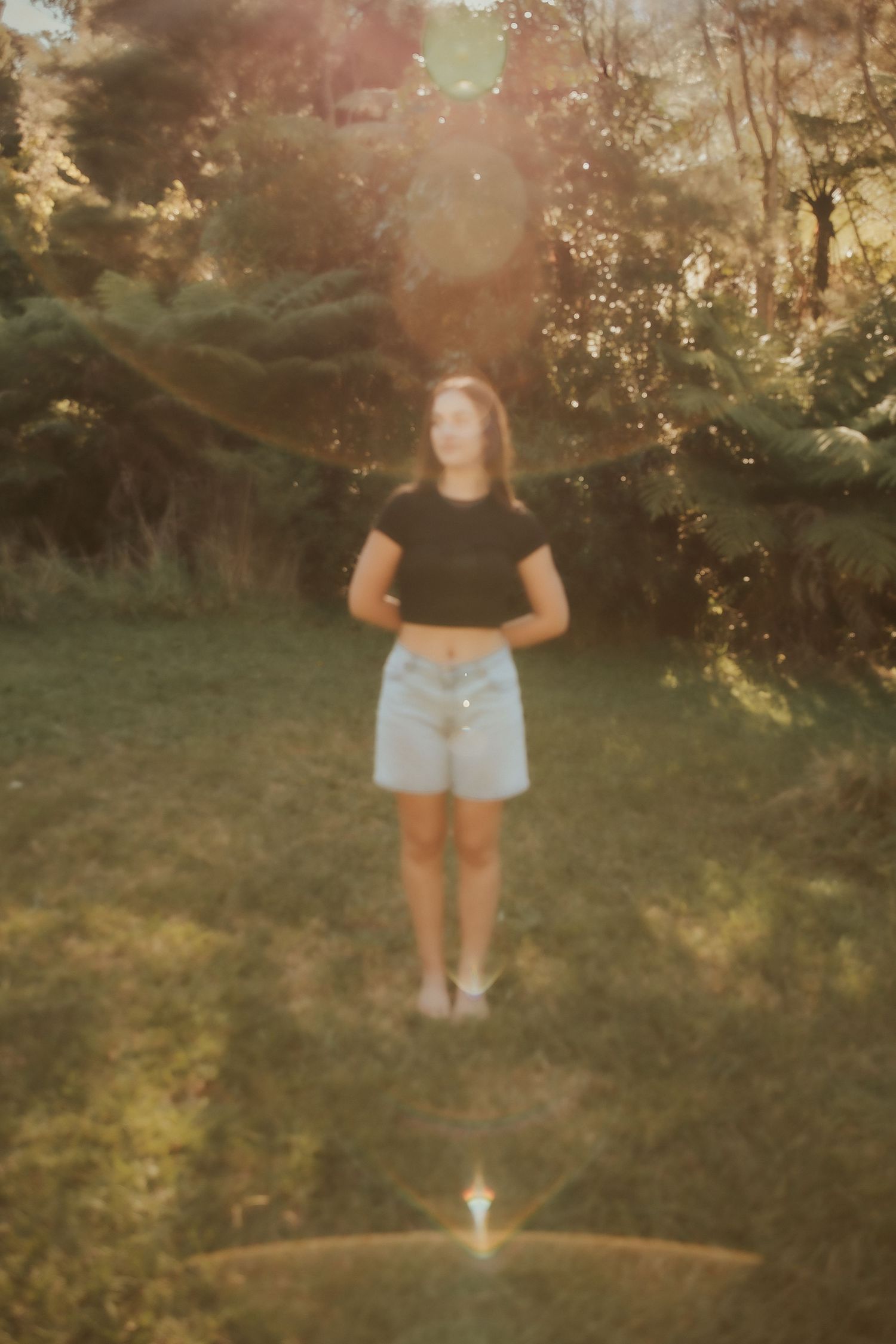Dreamy summer photoshoot with sun flares in backlit garden setting.