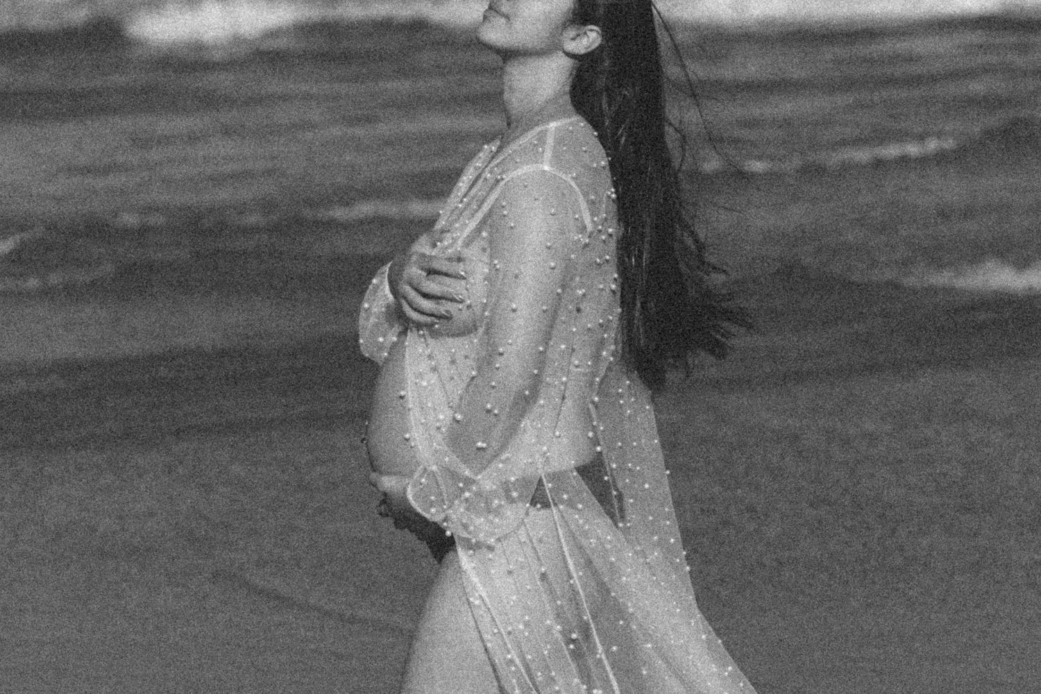Artistic black and white portrait series featuring a sheer dress against a cloudy sky.