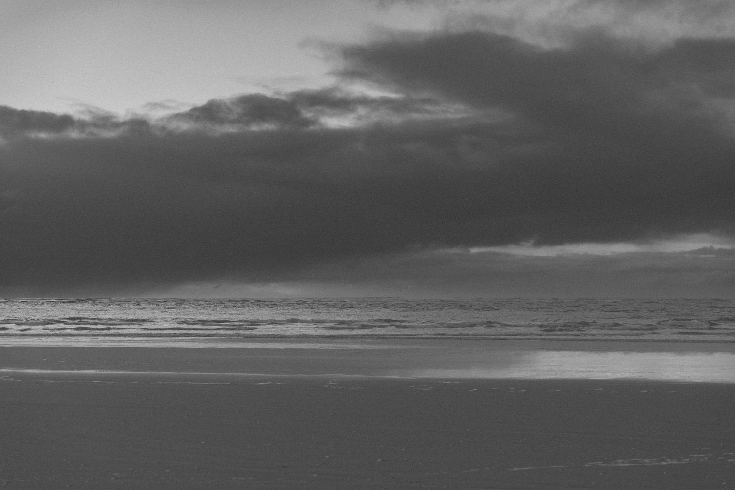 Dramatic seascape with stormy clouds and ocean waves under moody lighting.