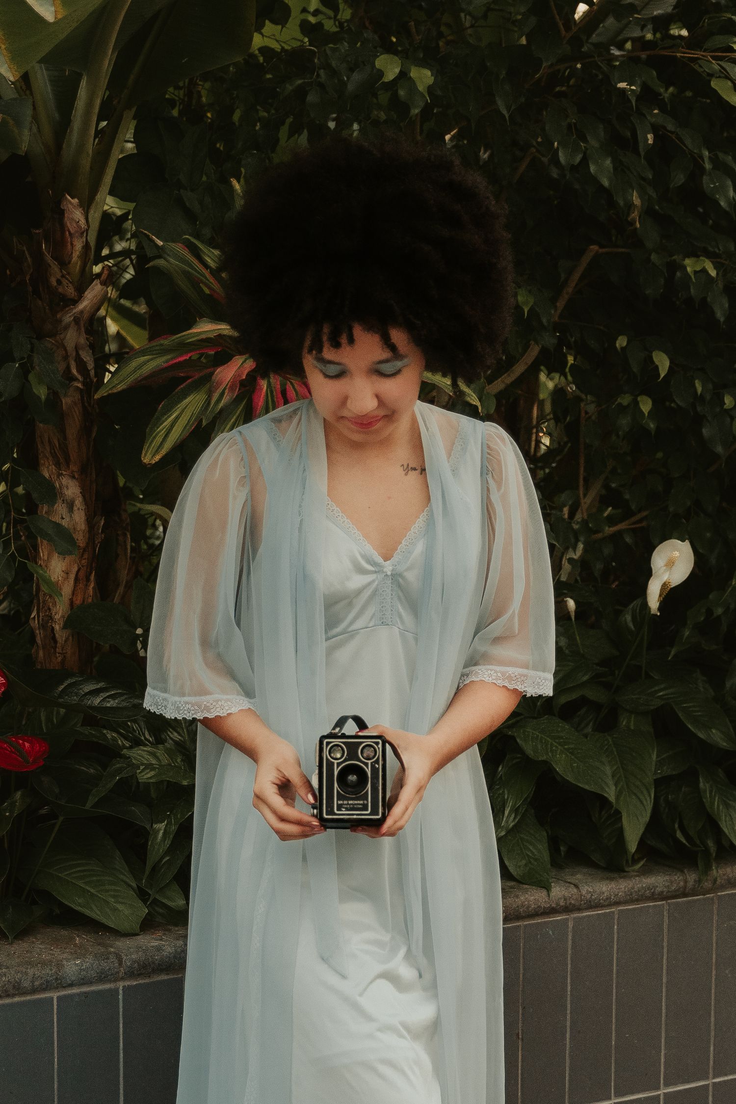 Vintage-inspired photo session with antique camera and pale blue dress.