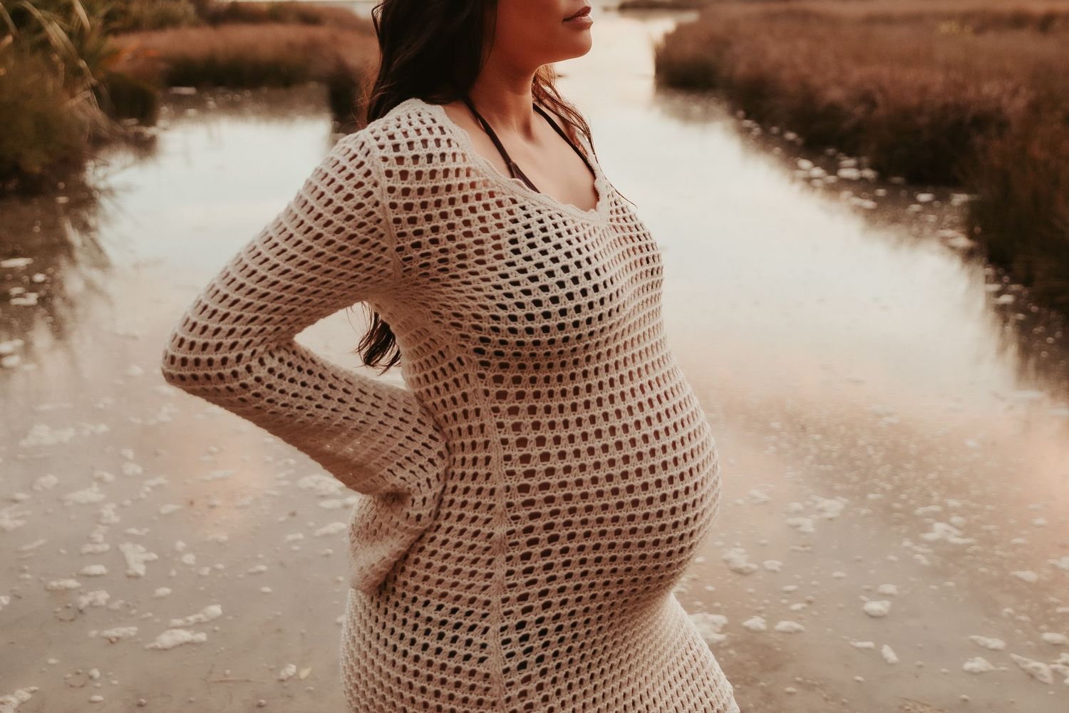 Artistic maternity photo series showing pregnant belly in soft evening light.