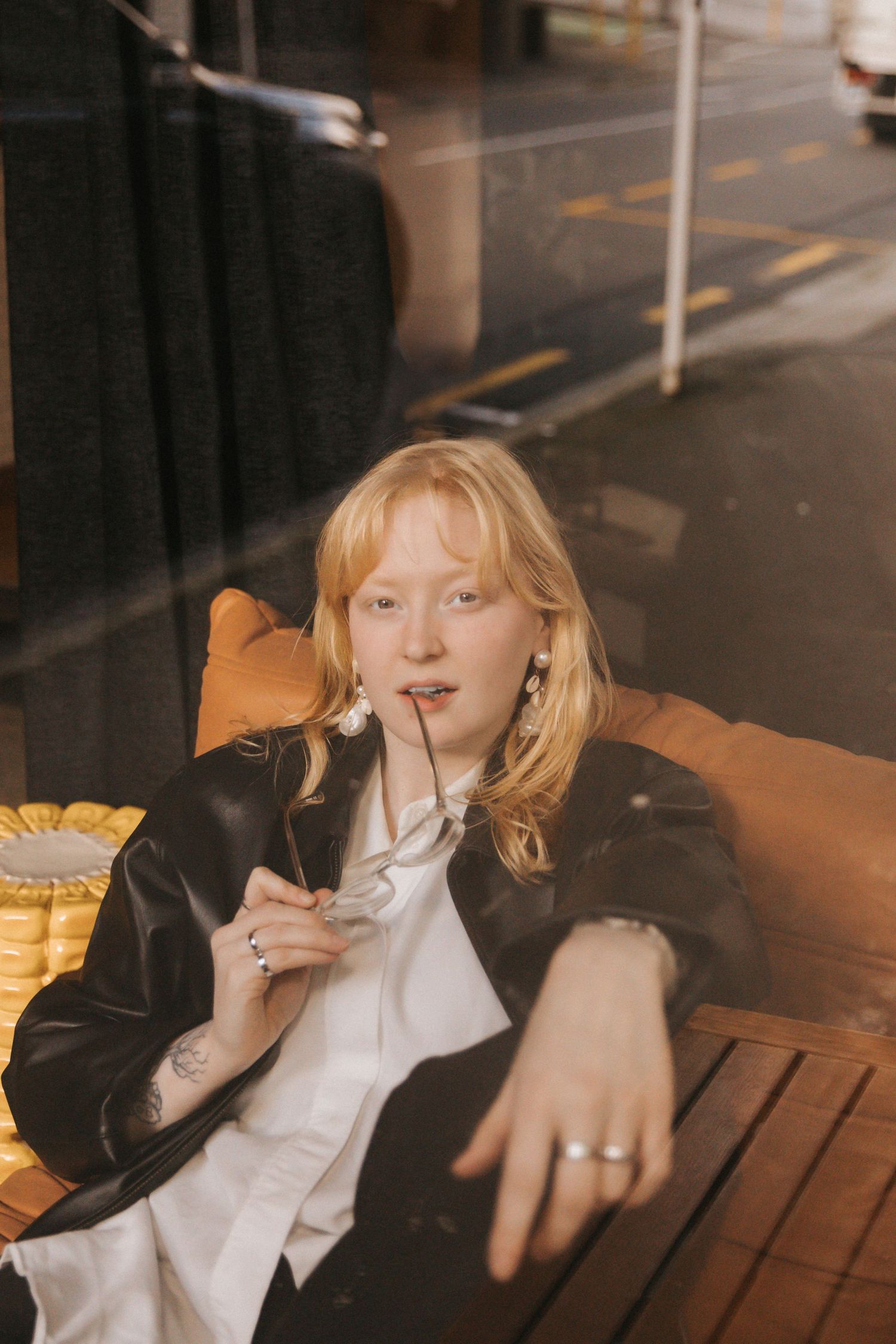 A person in a black leather jacket and white shirt poses in a series of connected moody nighttime portraits.