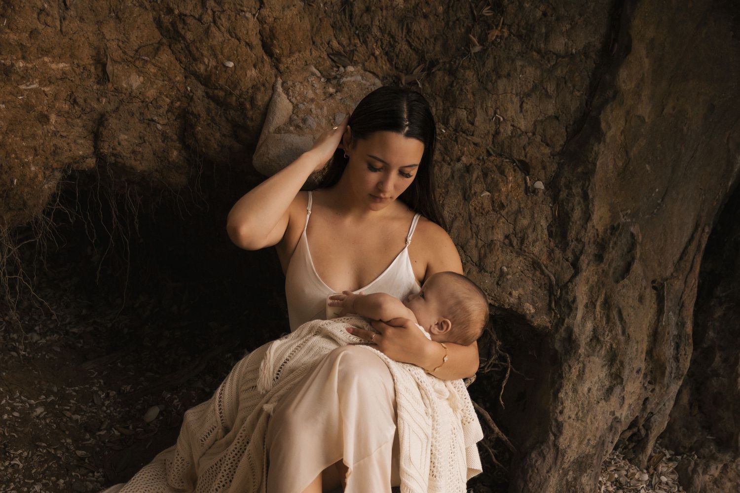 Artistic photography in a cave setting with dramatic lighting and natural stone elements.
