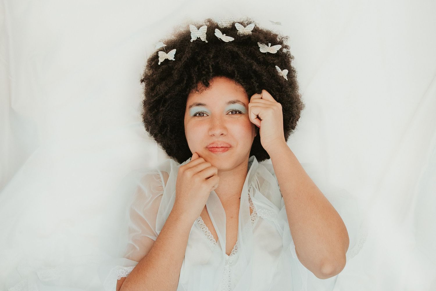 Dreamy portrait with white butterflies against light background.