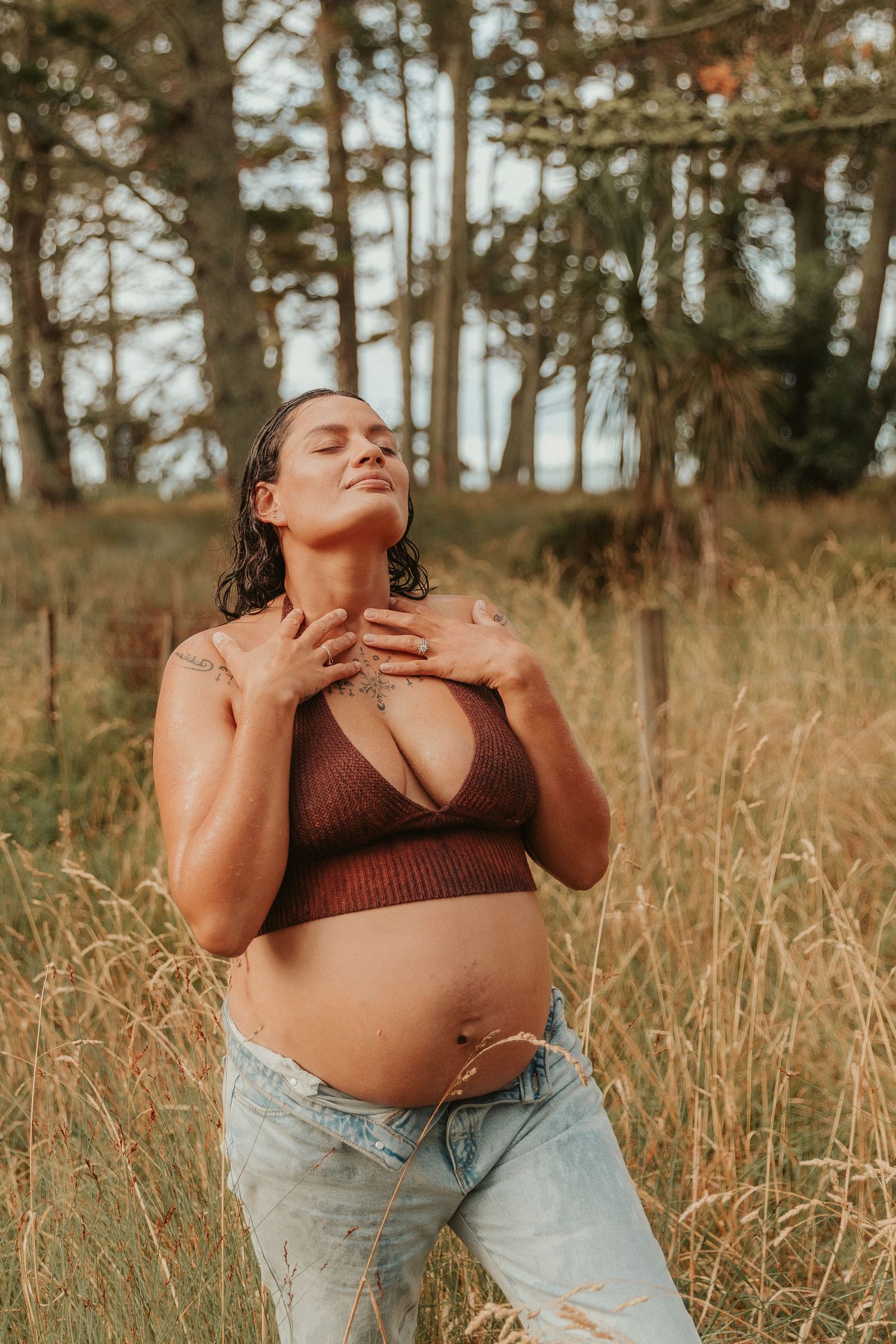 A series of artistic outdoor maternity portraits in a golden field with tall grass and pine trees in the background.