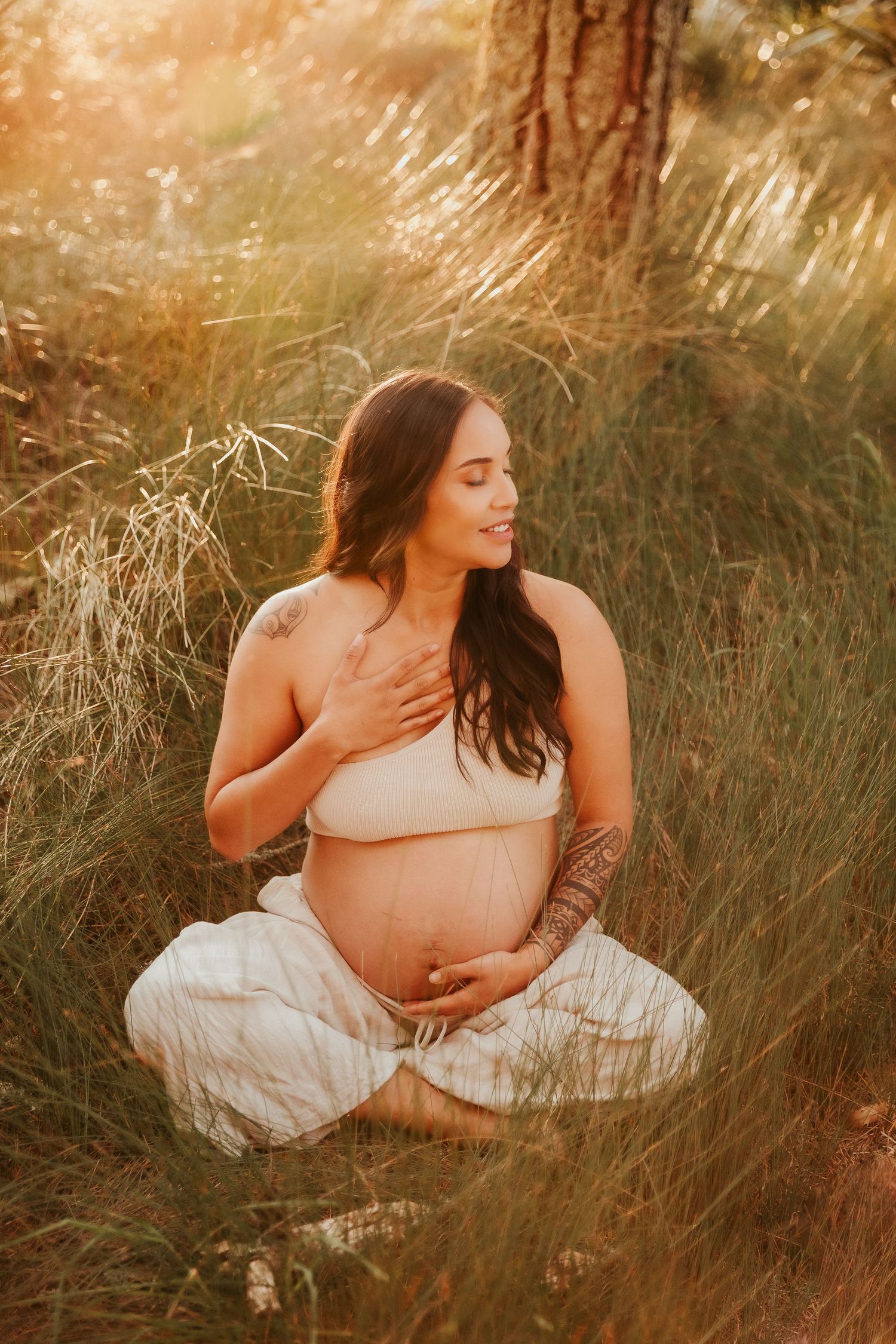 Intimate portrait session in sun-kissed coastal grasslands during golden hour.