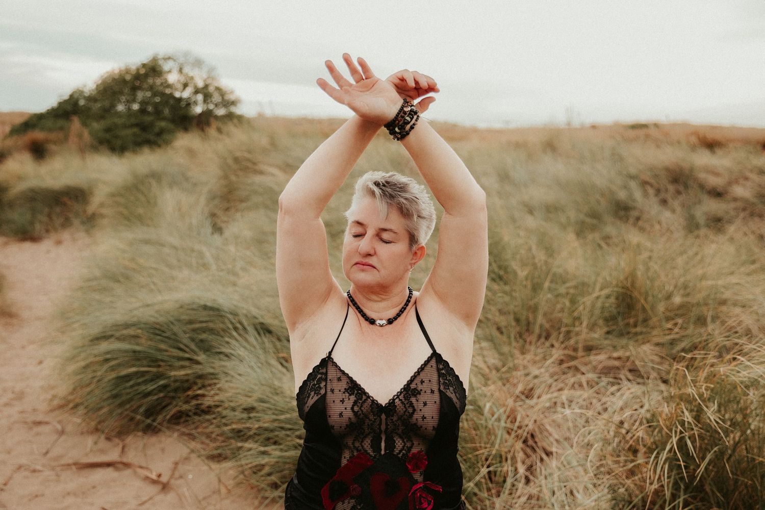 Artistic poses against natural grassland backdrop in warm evening light.