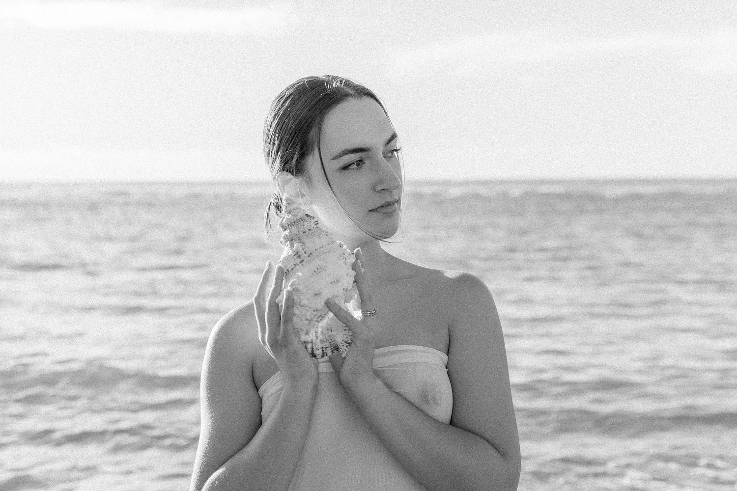 Black and white portrait series showing emotional expressions against ocean backdrop.