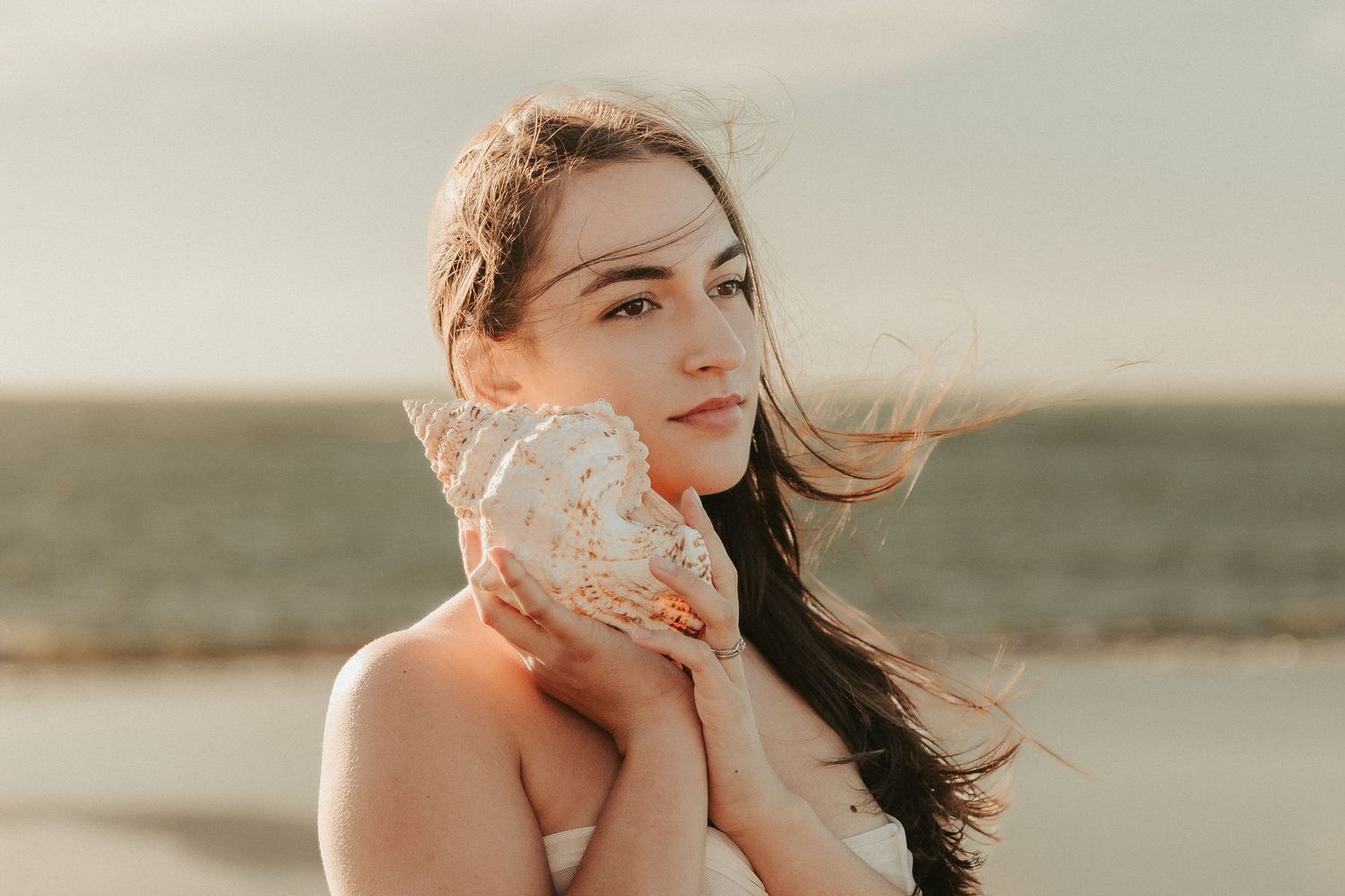 Ethereal beach photoshoot with dreamy lighting and coastal scenery.