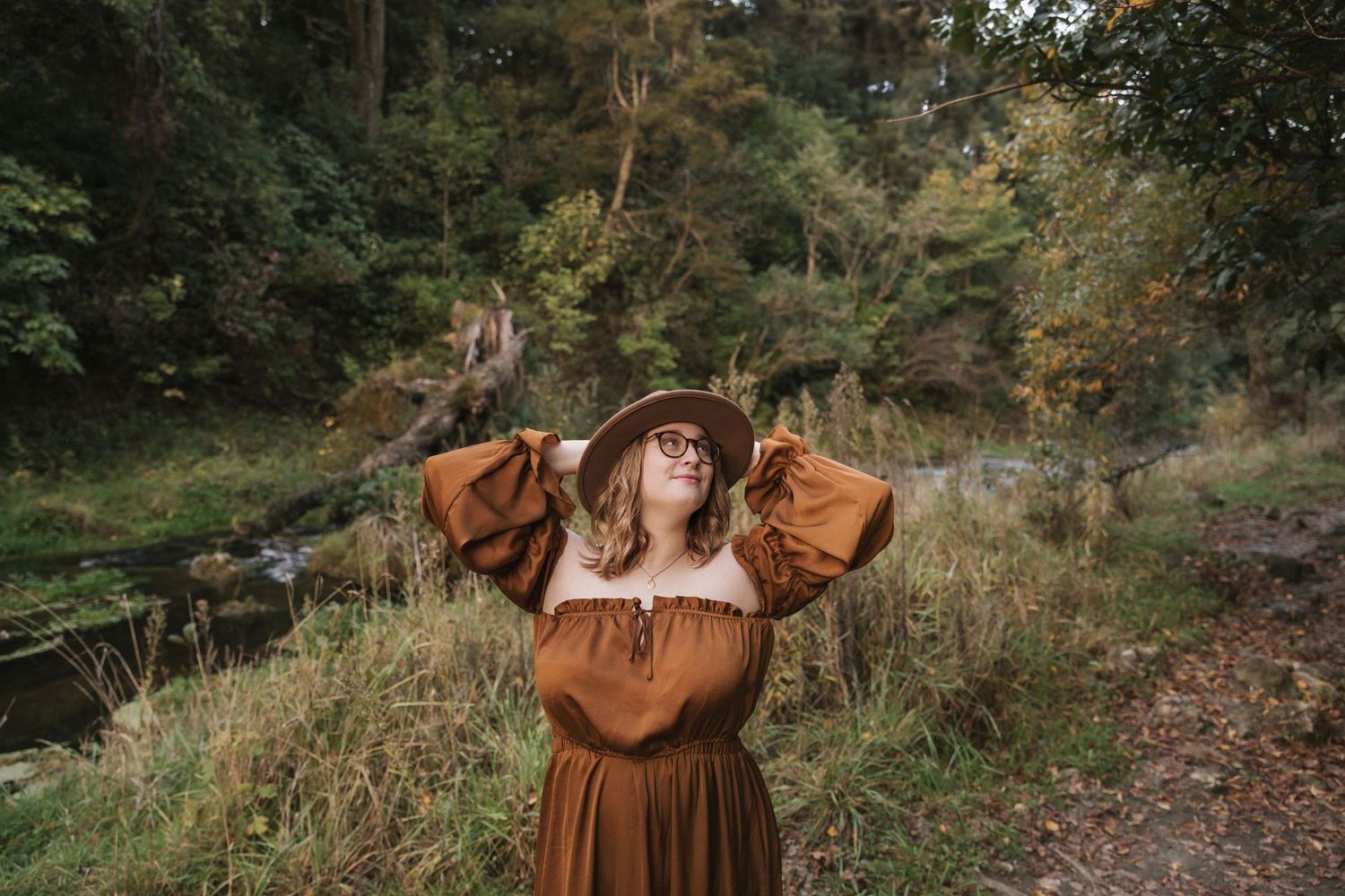 Rustic autumn fashion photography featuring earth tones against natural woodland backdrop.