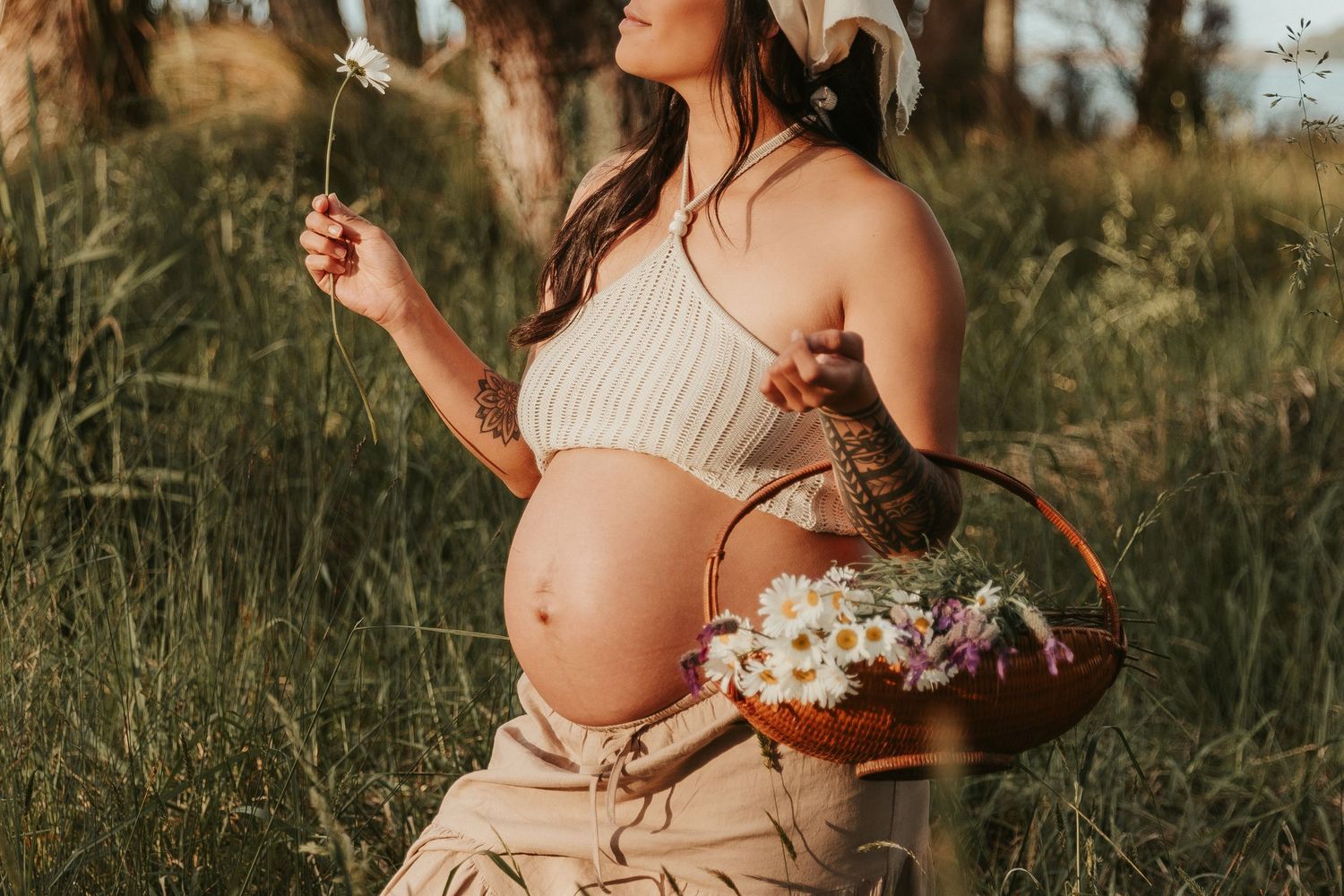 A series of maternity photos showing a pregnant woman in a cream dress holding flowers in a golden-lit outdoor field.