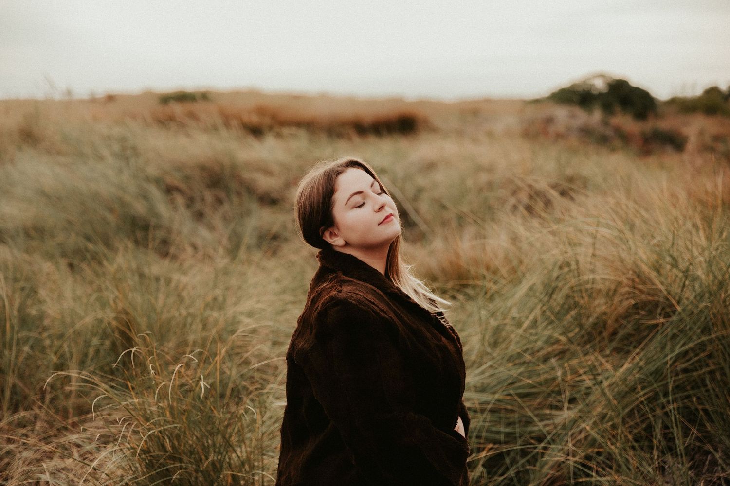 Emotive portrait sequence captured in golden grassland setting.