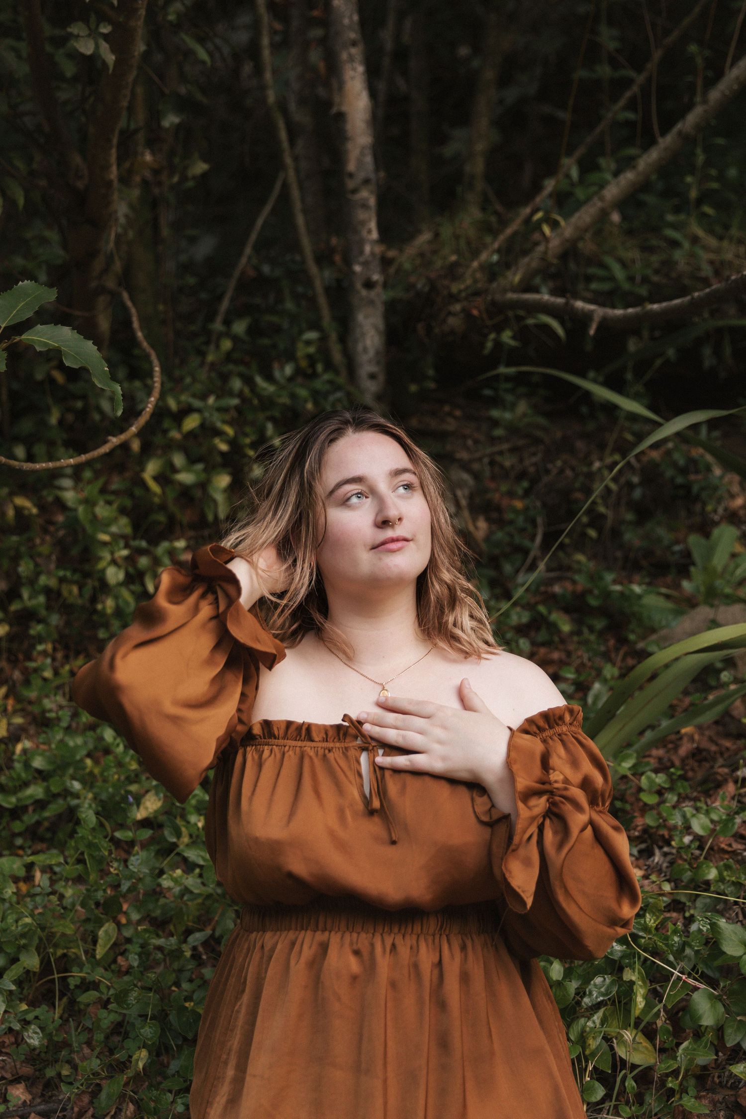 Artistic fashion portraits showcasing a brown vintage-inspired dress among forest greenery.