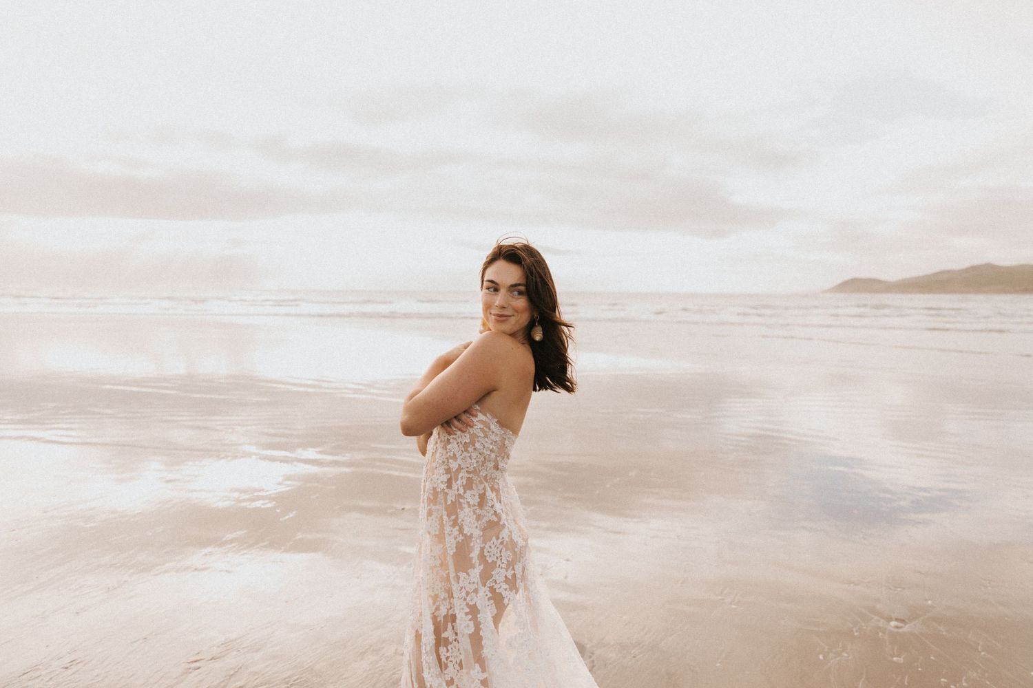 Artistic beach portrait series with flowing white dress.