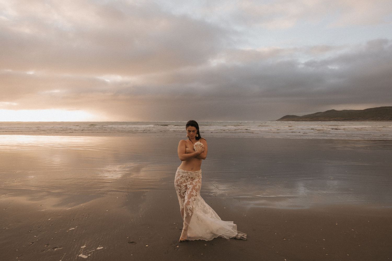 A dreamy beach landscape with flowing fabric catching the golden light.