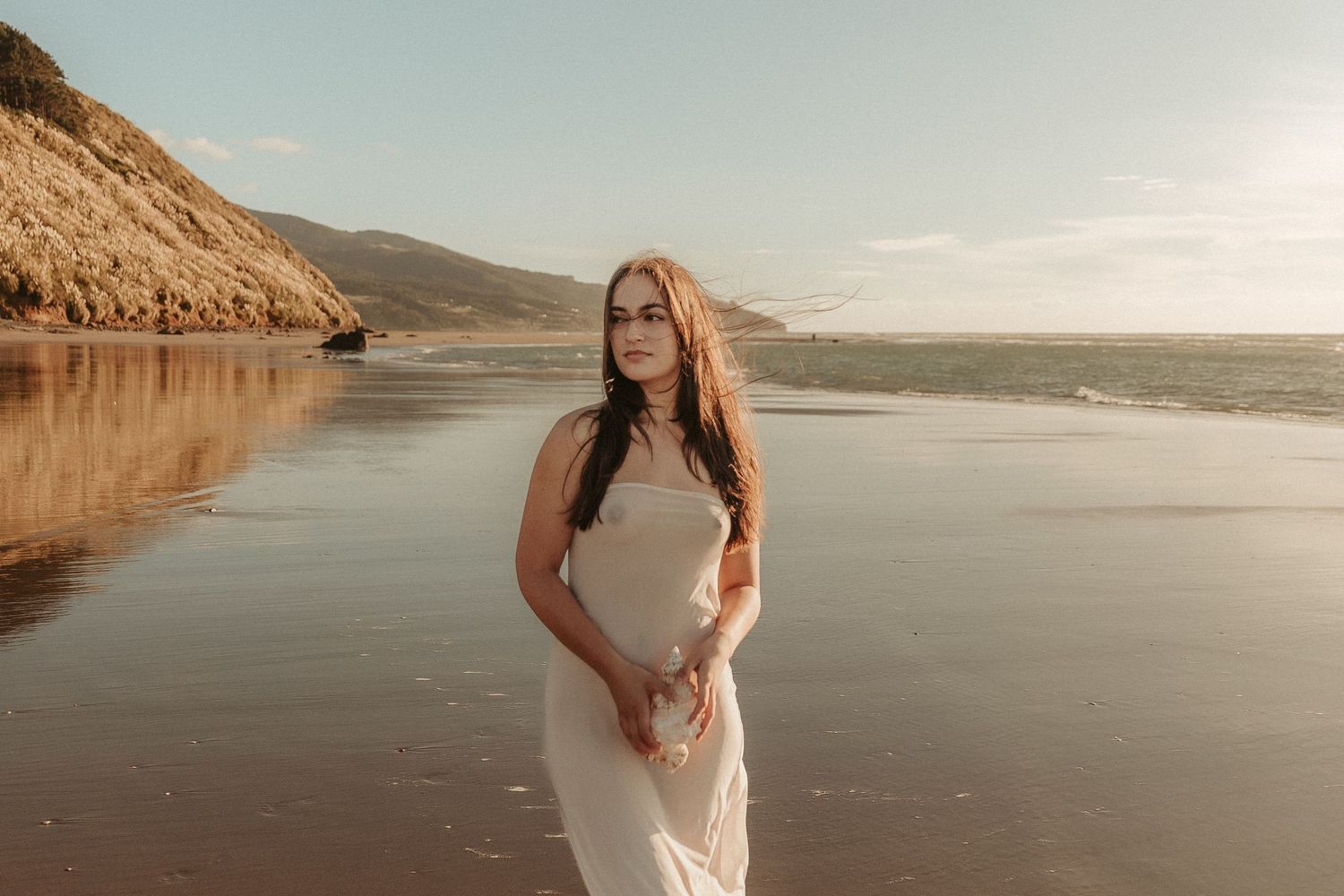 Peaceful maternity portraits captured on a secluded beach at golden hour.