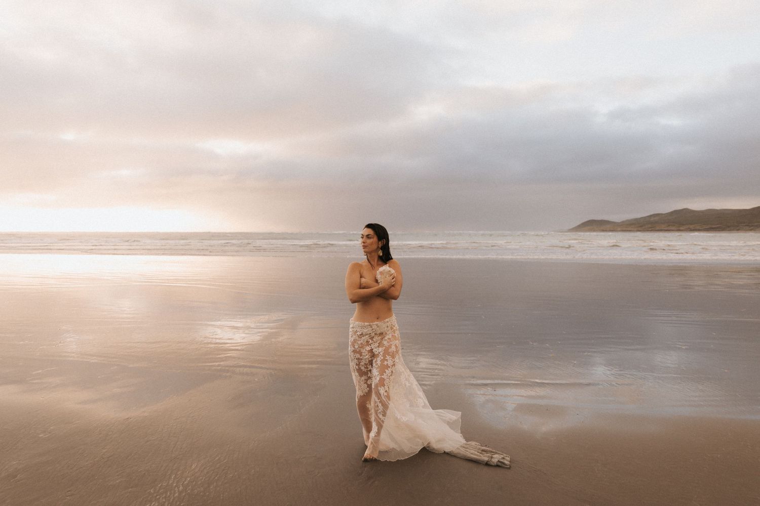 An ethereal beach photoshoot with flowing fabric against the sunset.