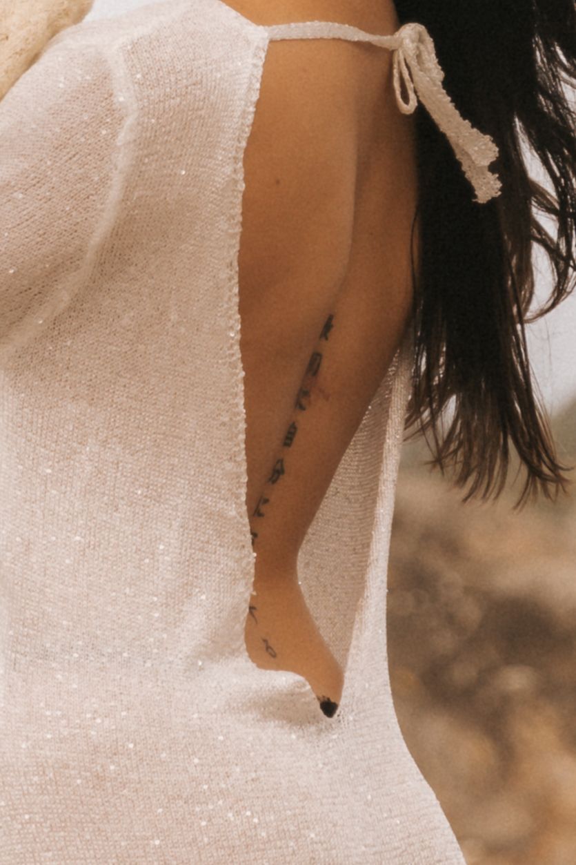 Close-up detail of a sparkly white dress with delicate beading and texture.
