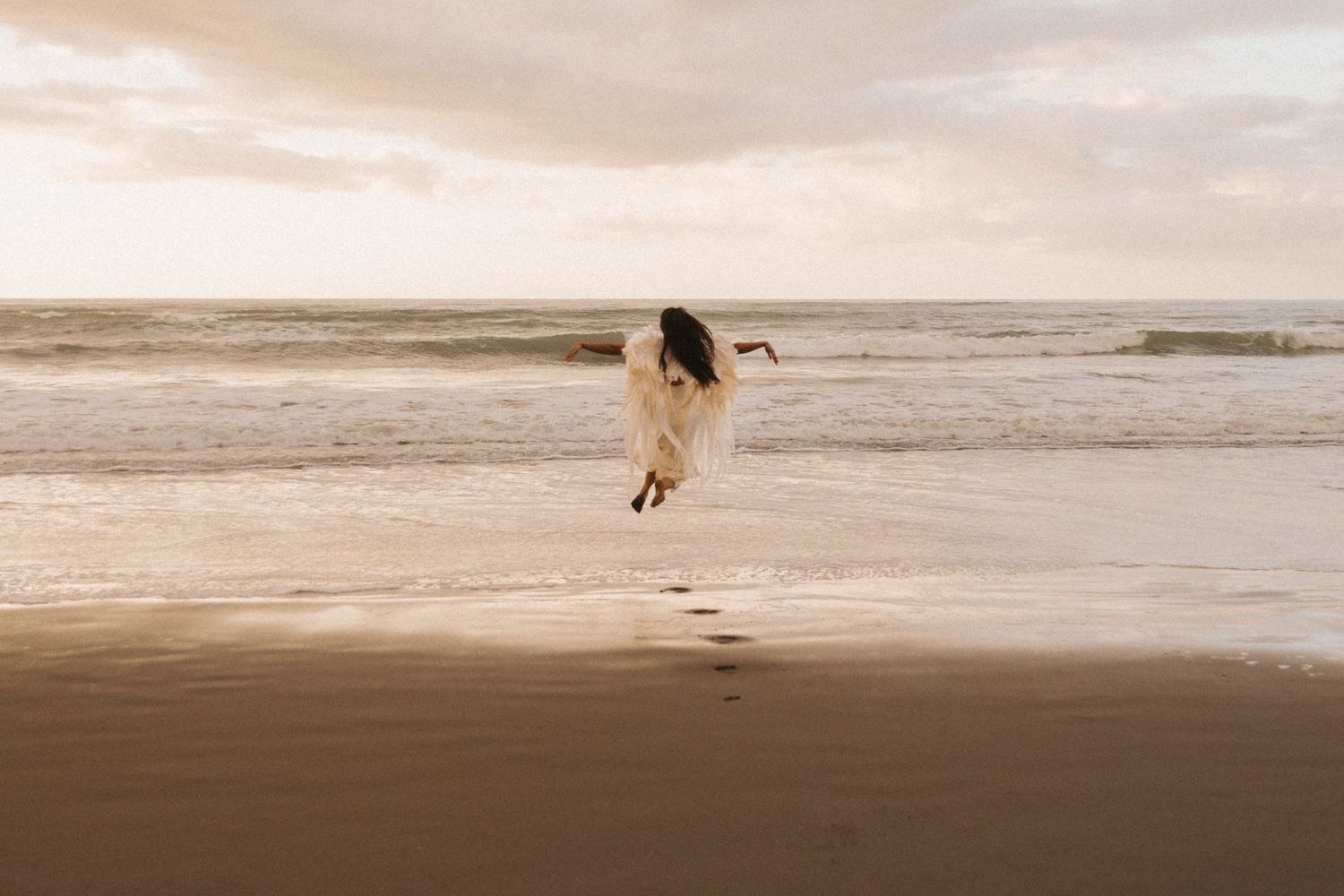 A serene seascape with waves crashing on a sandy beach at sunset, creating a peaceful coastal atmosphere.