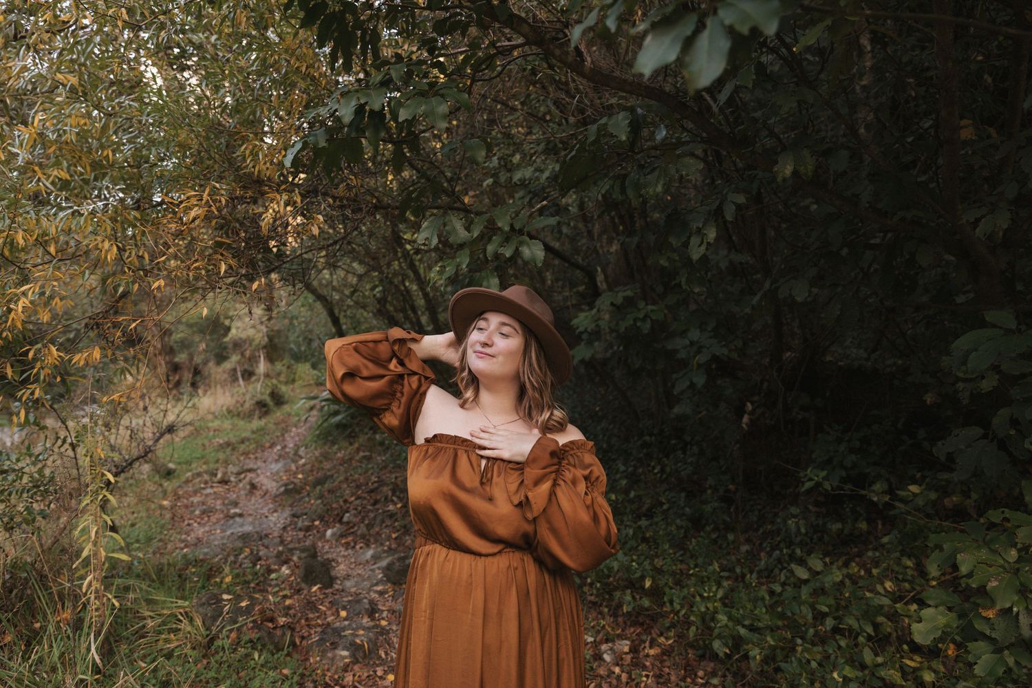 Whimsical outdoor fashion series with brown dress against moody forest background.
