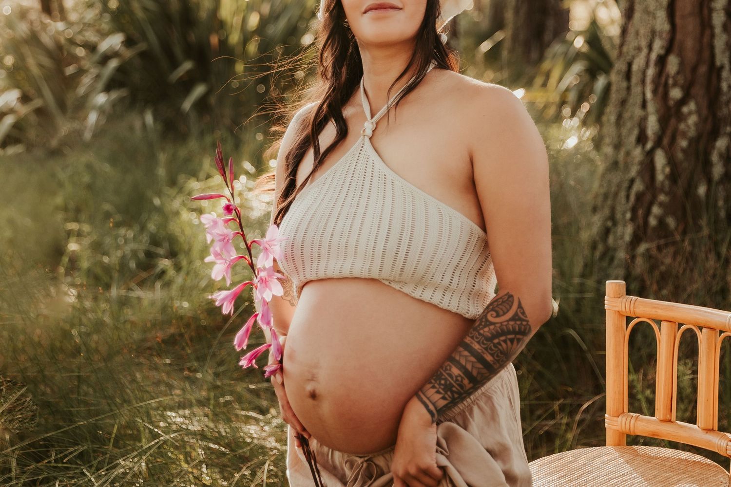 Maternity photoshoot in natural outdoor setting with soft golden lighting.