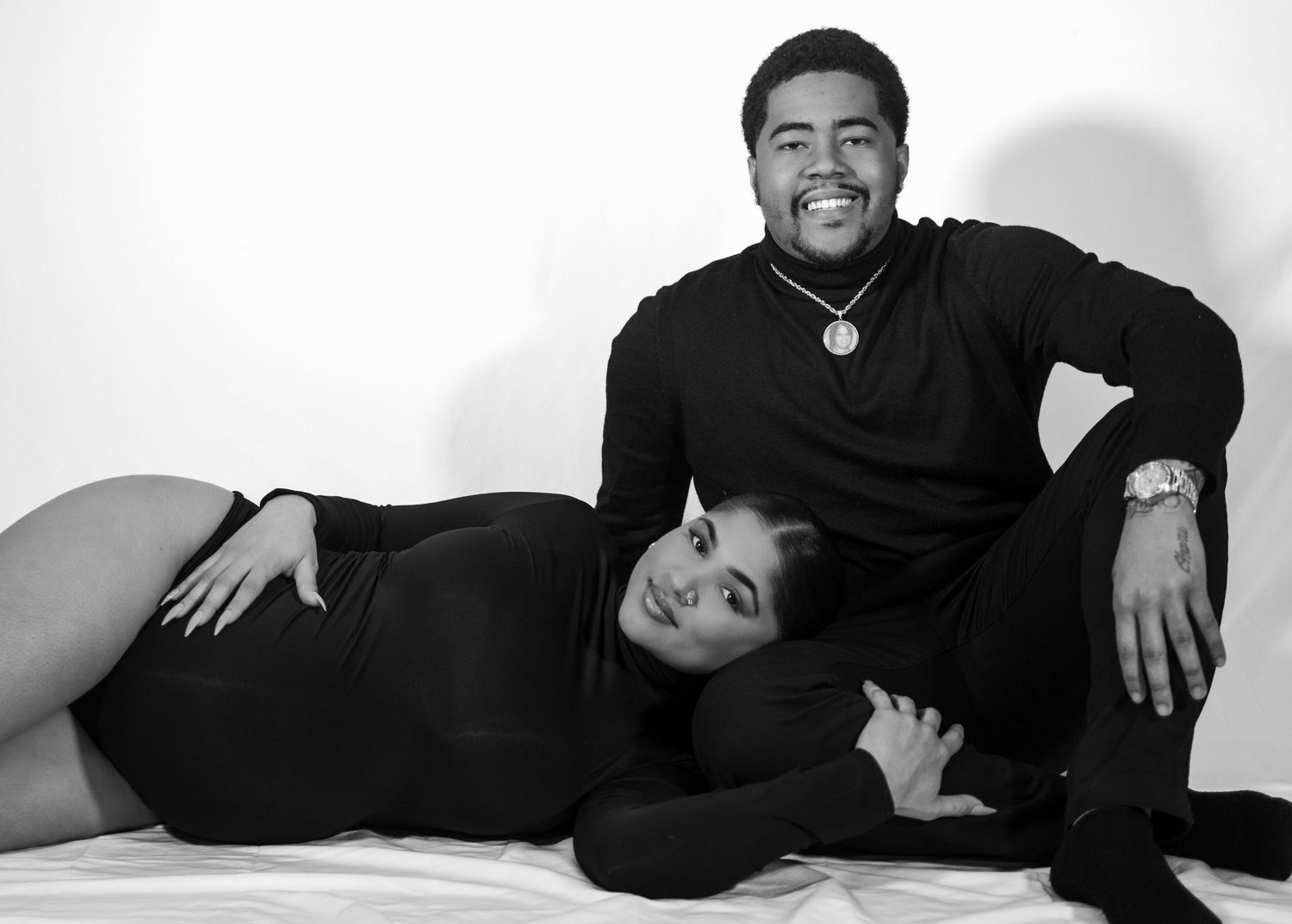 People posing in simple black and white studio portraits on a light background.