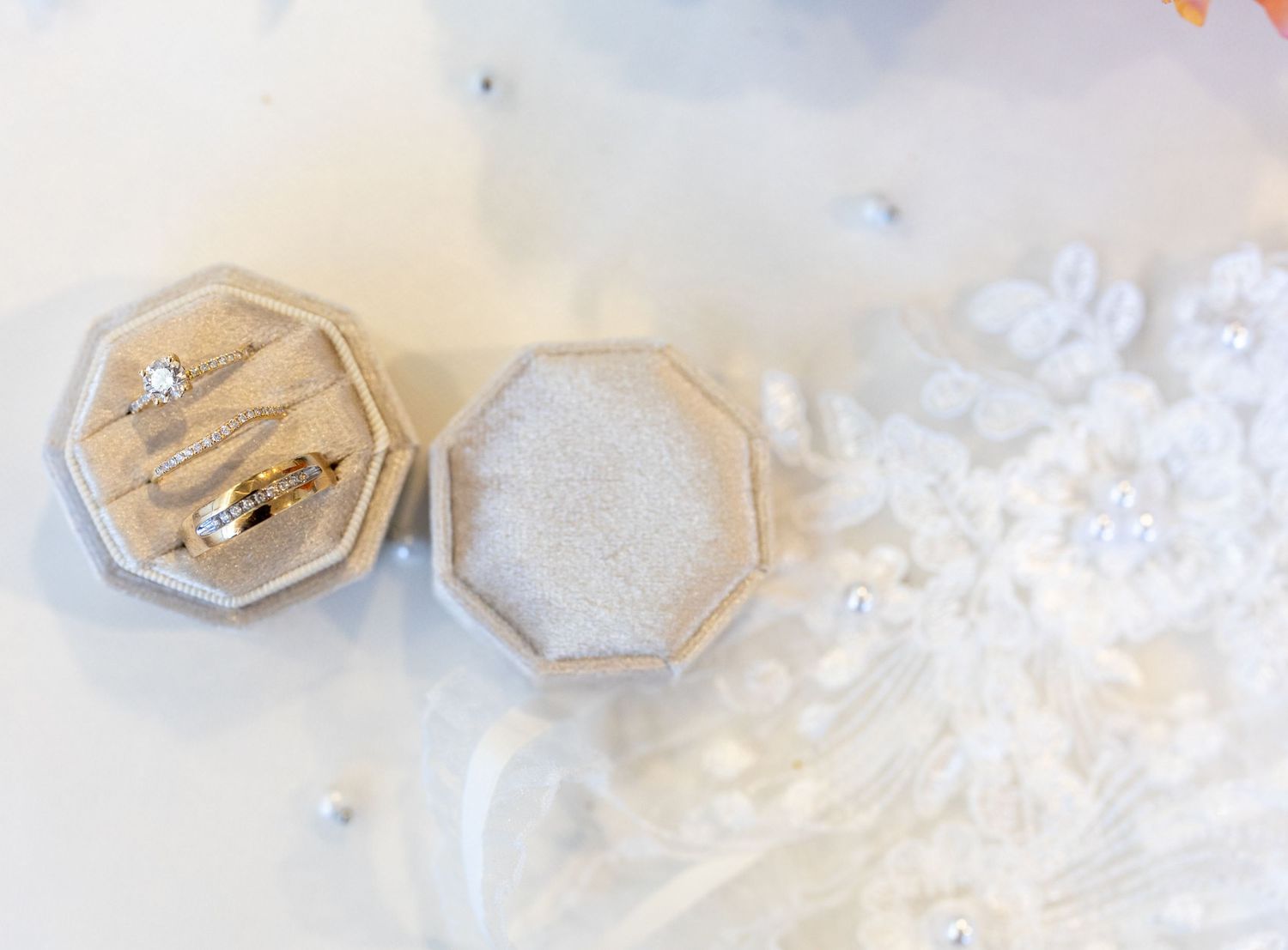 Wedding rings in hexagonal ring boxes with delicate white lace details.