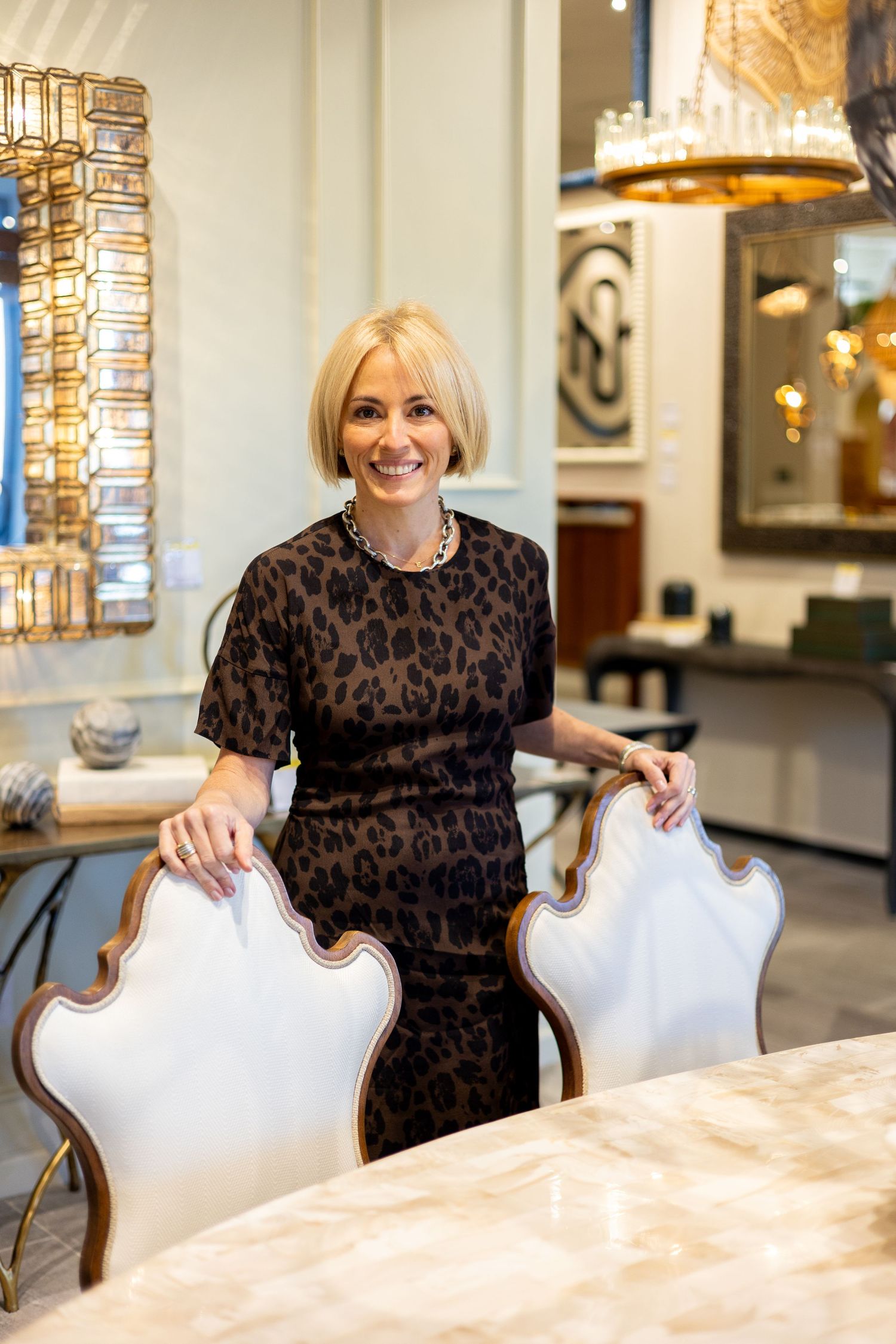 A sequence of photos showing someone in a leopard print top sitting at a white marble table with elegant chairs.