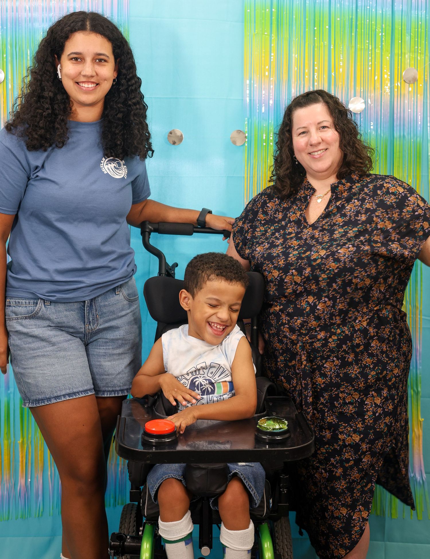 Group photo against a colorful blue and green striped background with some wearing matching blue shirts.