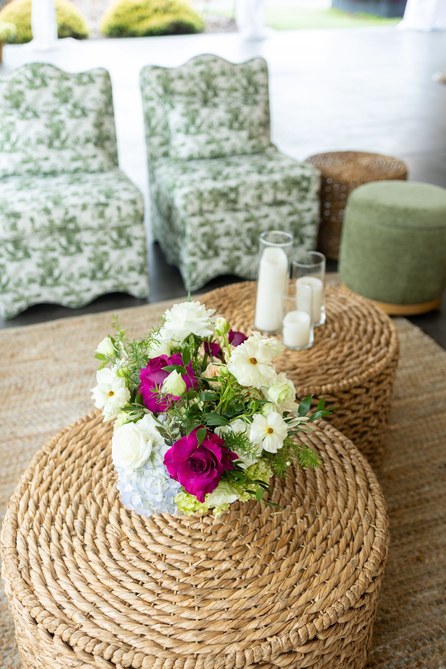 A natural woven round jute rug decorated with fresh white and magenta flowers creates a charming rustic centerpiece.