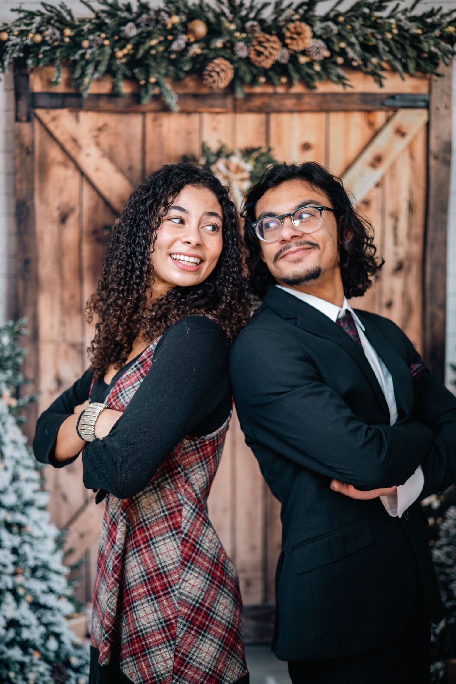 A couple in formal attire shares playful moments in a series of photos against a rustic wooden backdrop with greenery.