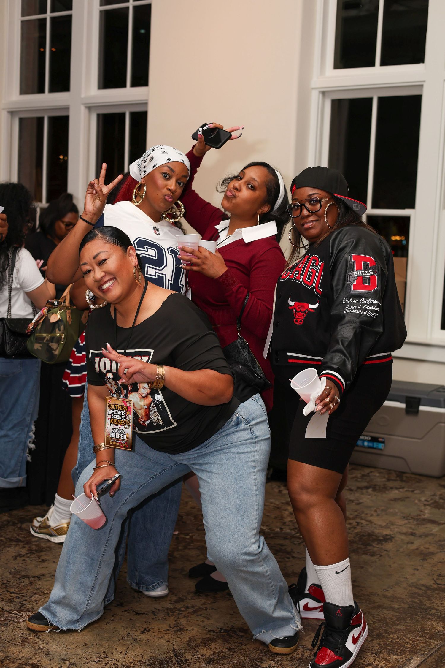 Group of friends in Chicago Bulls fan gear dancing and posing together in a fun sequence of movements.