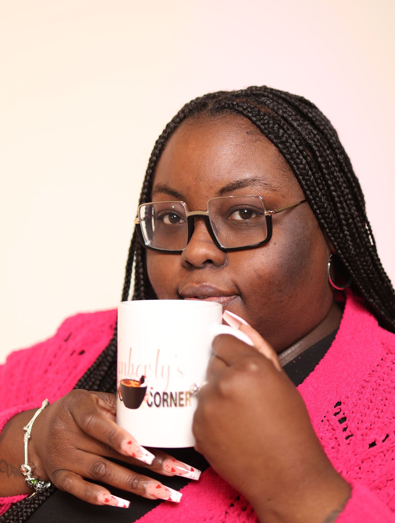 A sequence showing someone sipping from a white coffee mug while wearing glasses and a pink sweater.