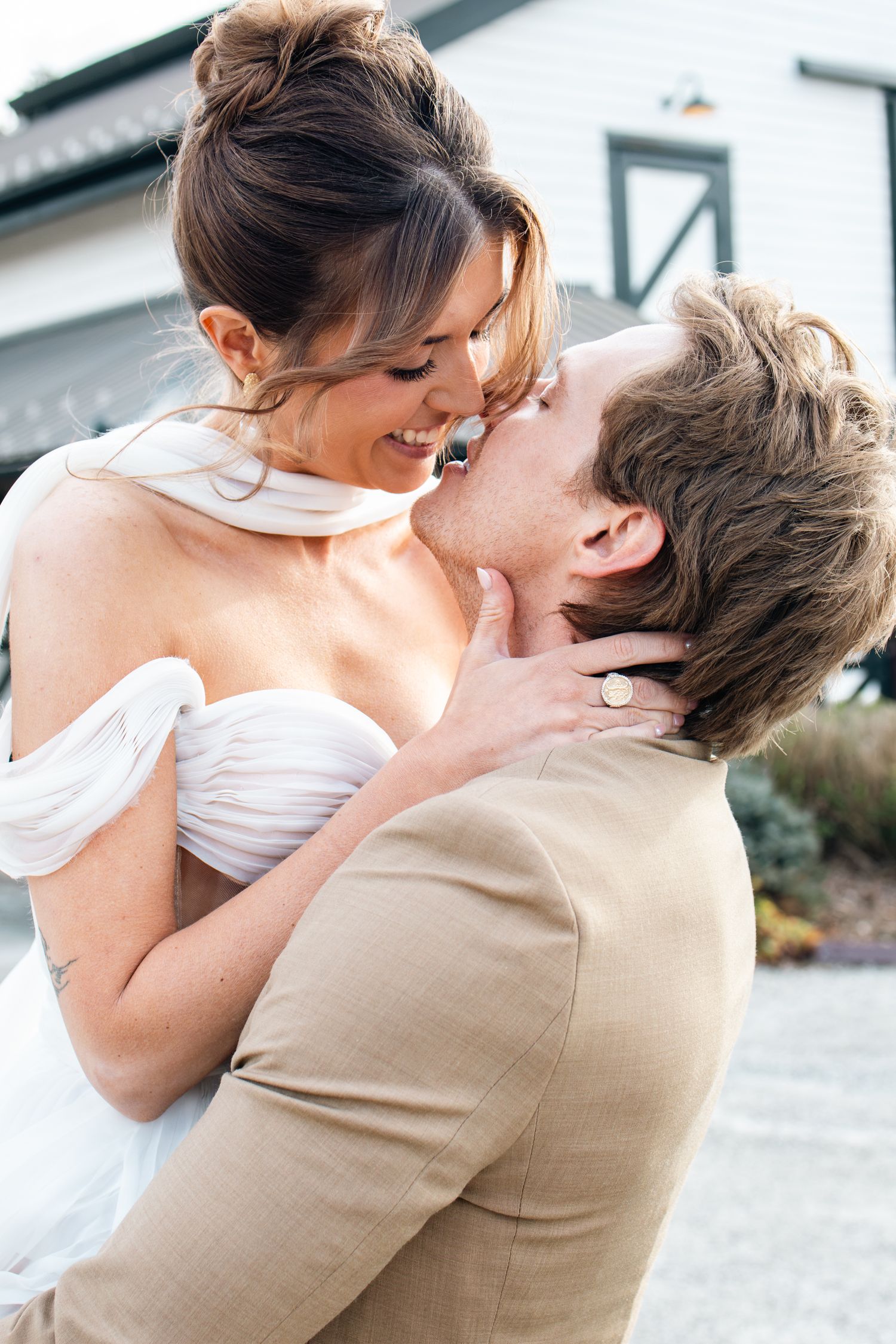 A romantic wedding couple shares tender kisses in a series of candid outdoor photographs in natural lighting.