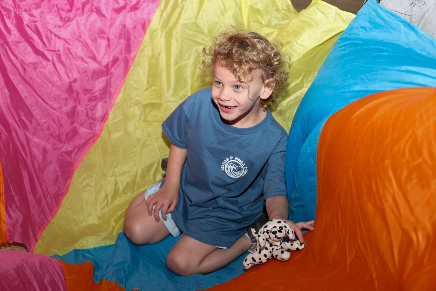 A colorful indoor play area with bright fabric panels and cushions.