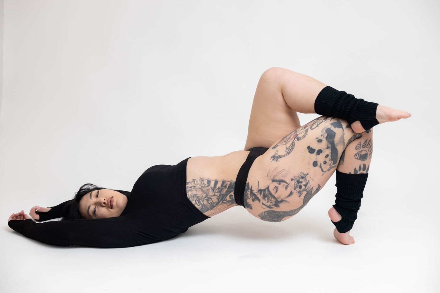 A series of artistic black and white boudoir photos showing a person in various reclining poses against a light background.