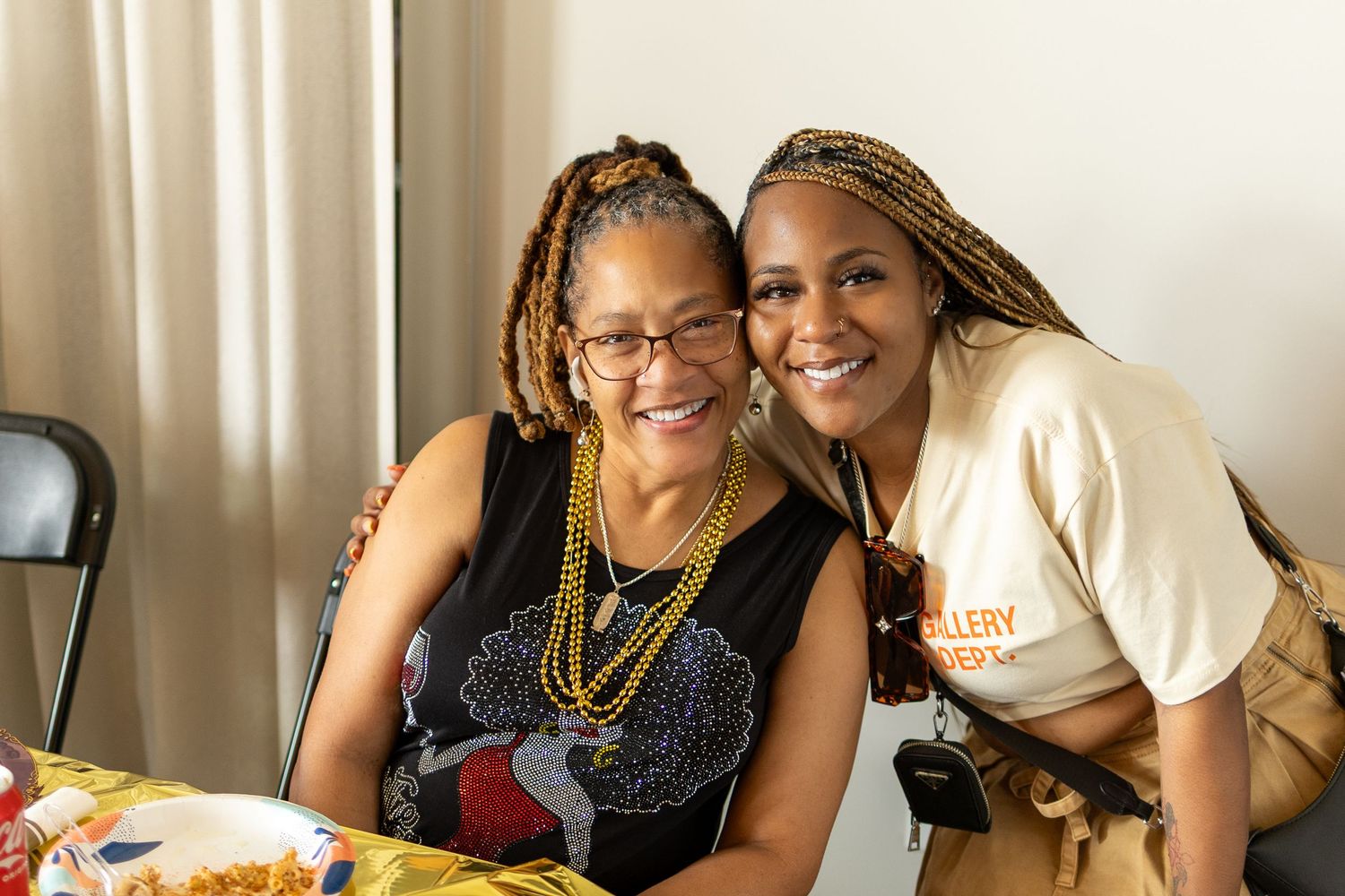 Two women sharing a joyful moment at a gathering.