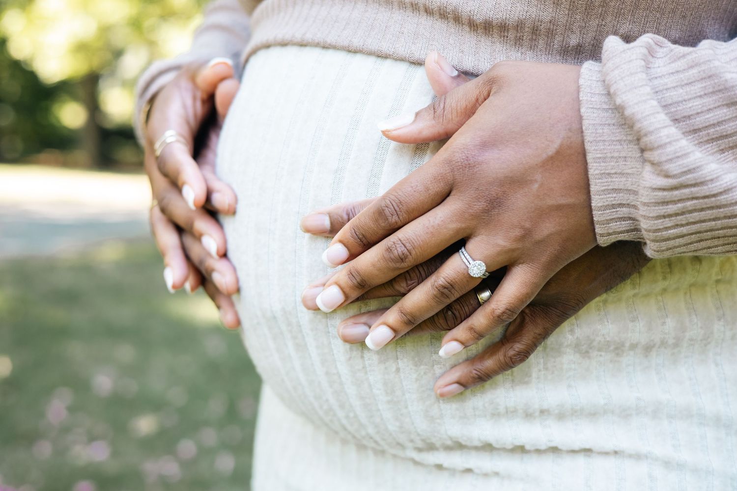 Close-up detail shots of hands wearing knit sweaters against a neutral background with natural lighting.