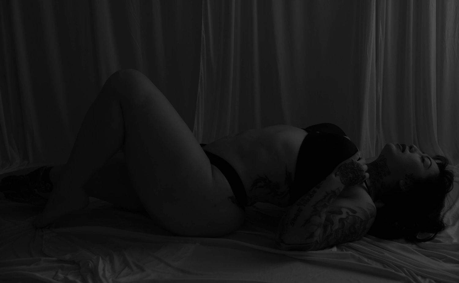 A dark bedroom scene with a person sleeping peacefully in a cozy bed at night.