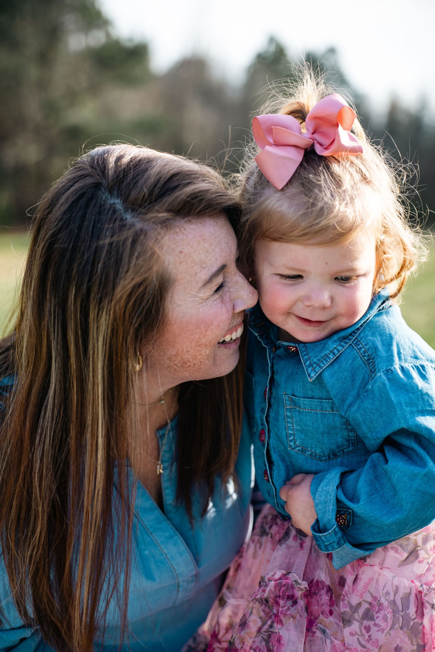 A tender moment between parent and child outdoors showing loving interaction and playful expressions.