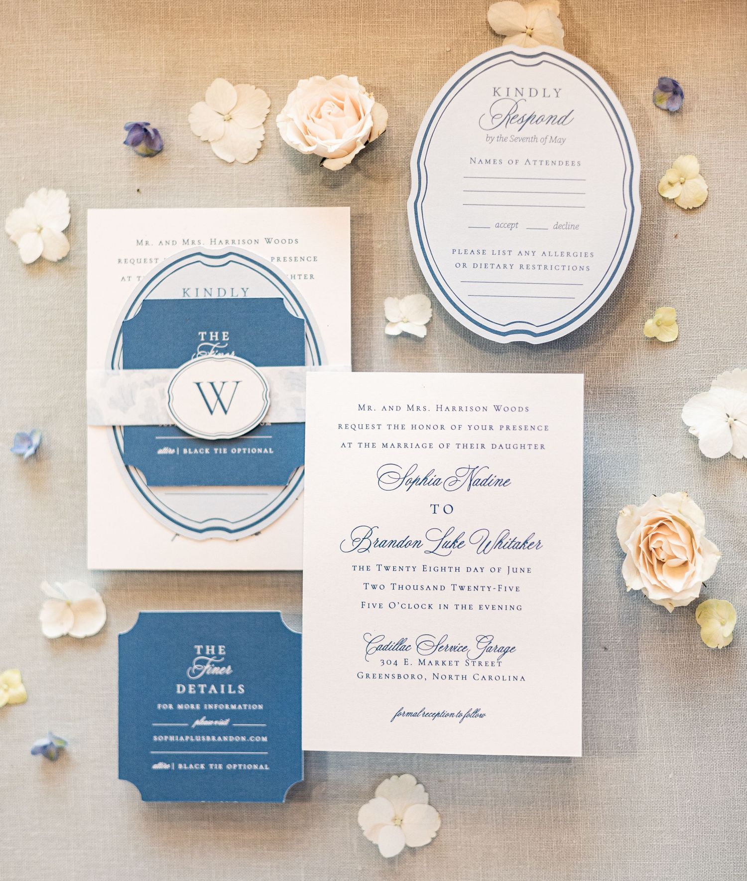 Elegant wedding invitation suite in navy blue and white with delicate floral accents and classic typography.