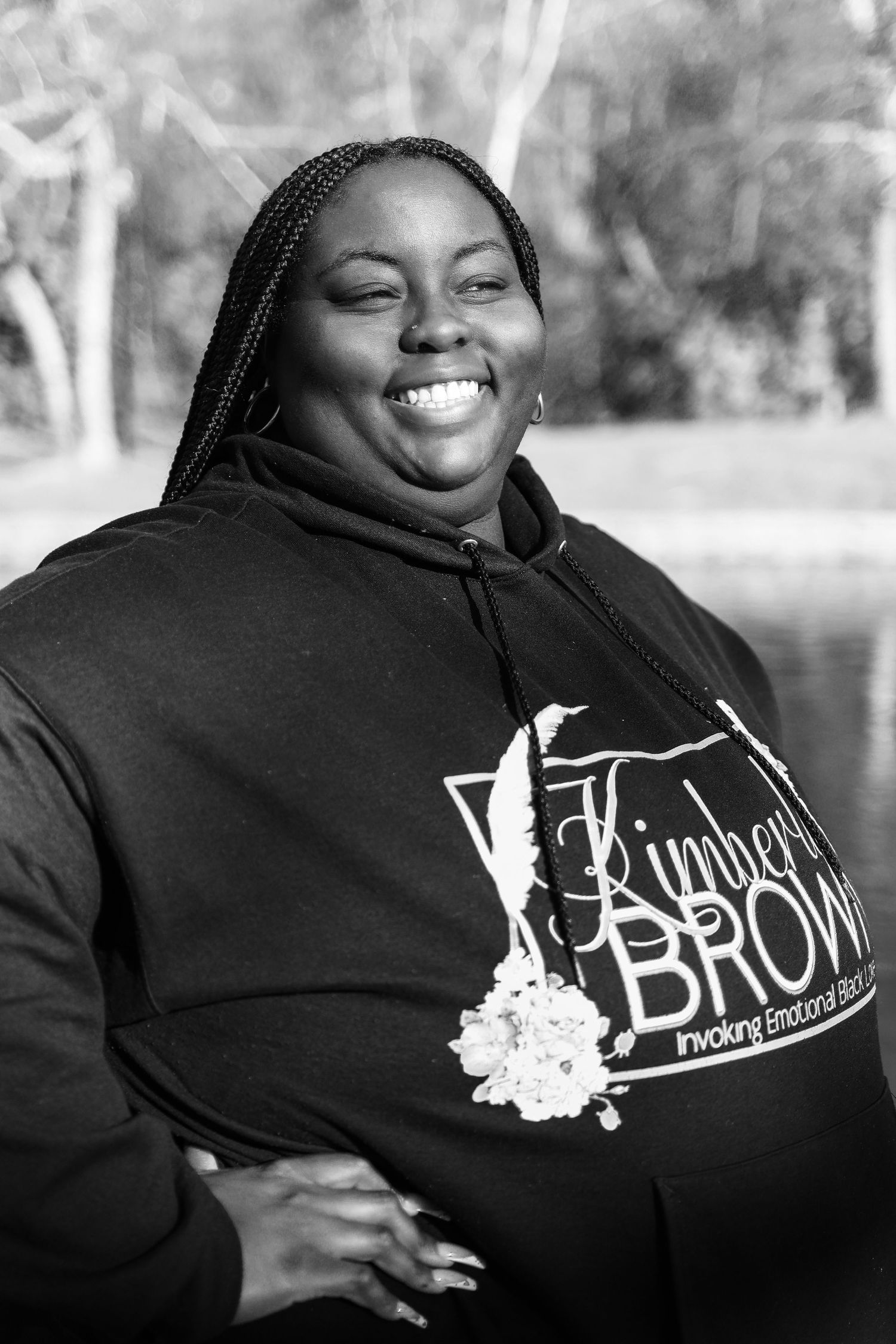 A black and white photo series showing someone wearing a black hoodie with white lettering while smiling and laughing.