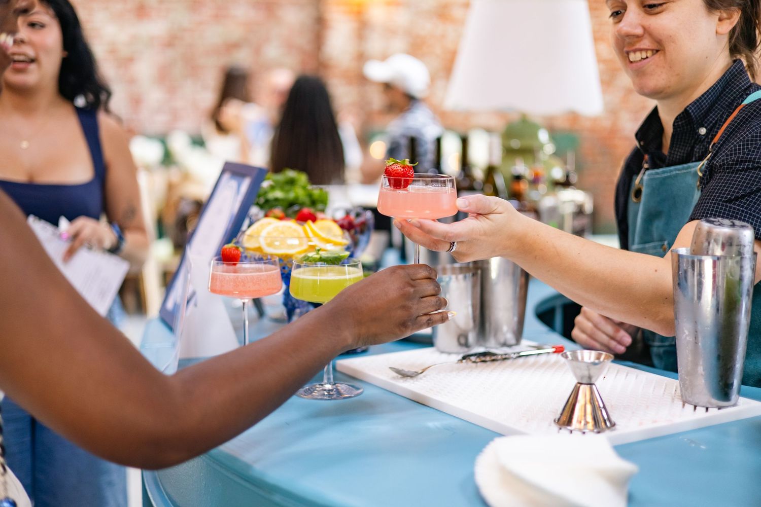 People's hands are shown around a table with drinks and appetizers during a social gathering.