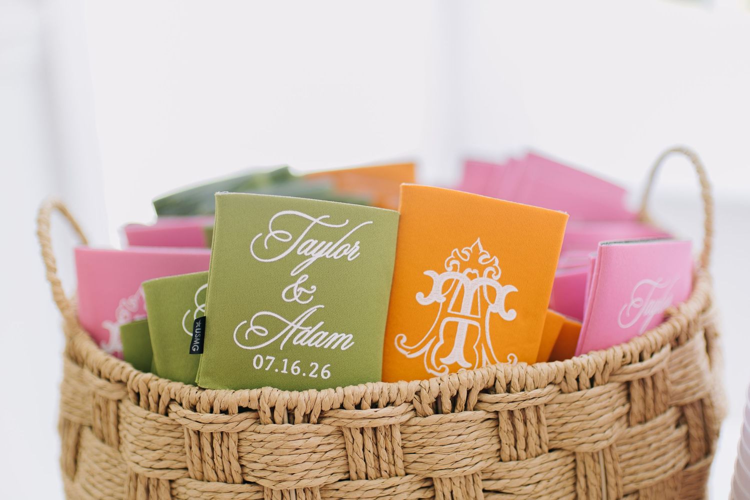Colorful personalized wedding favor booklets for Taylor and Adam in a woven basket, dated 07.16.26.