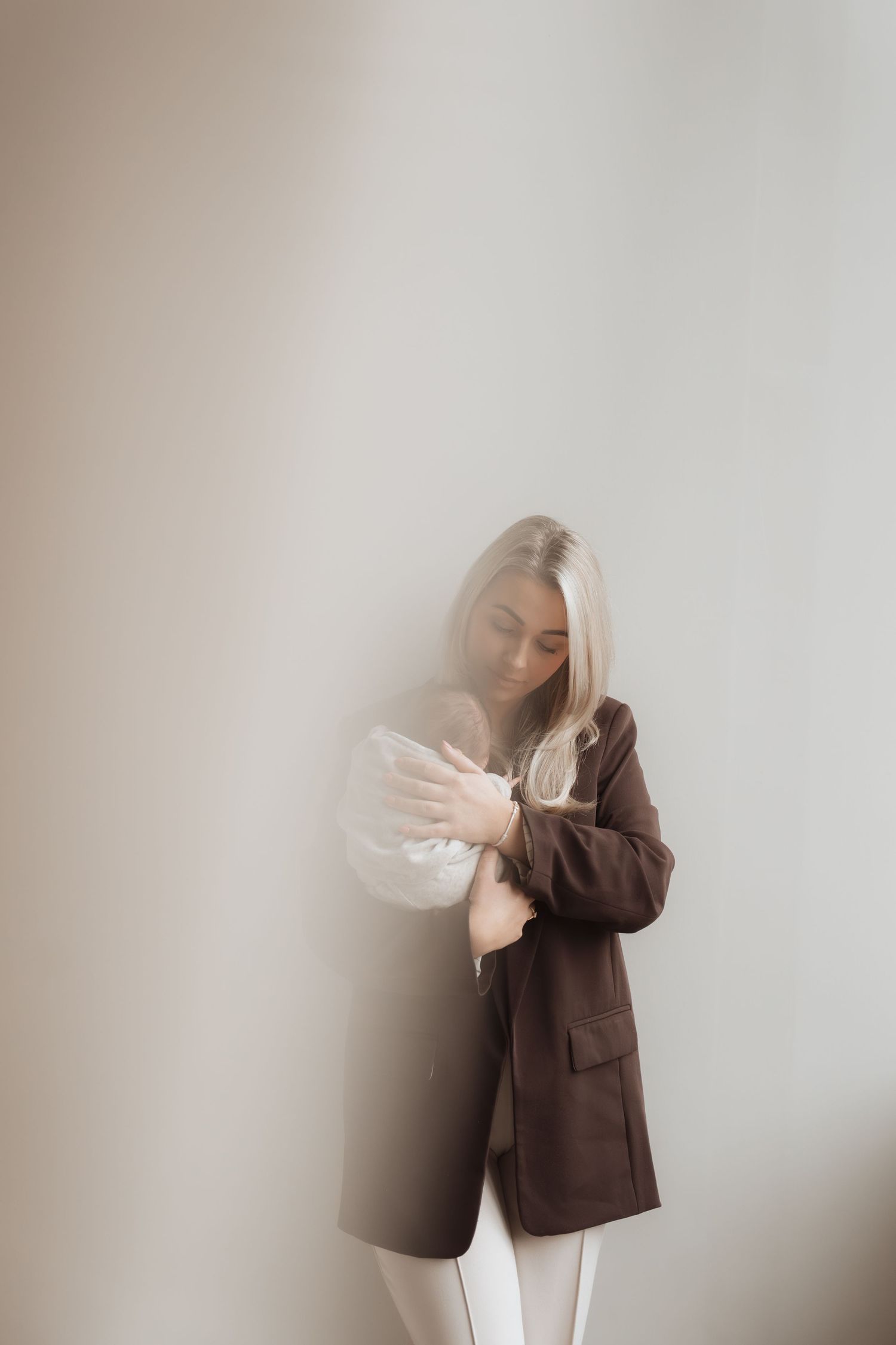 Artistic photo sequence showing a person in brown blazer with dramatic movement and light effects against neutral background.