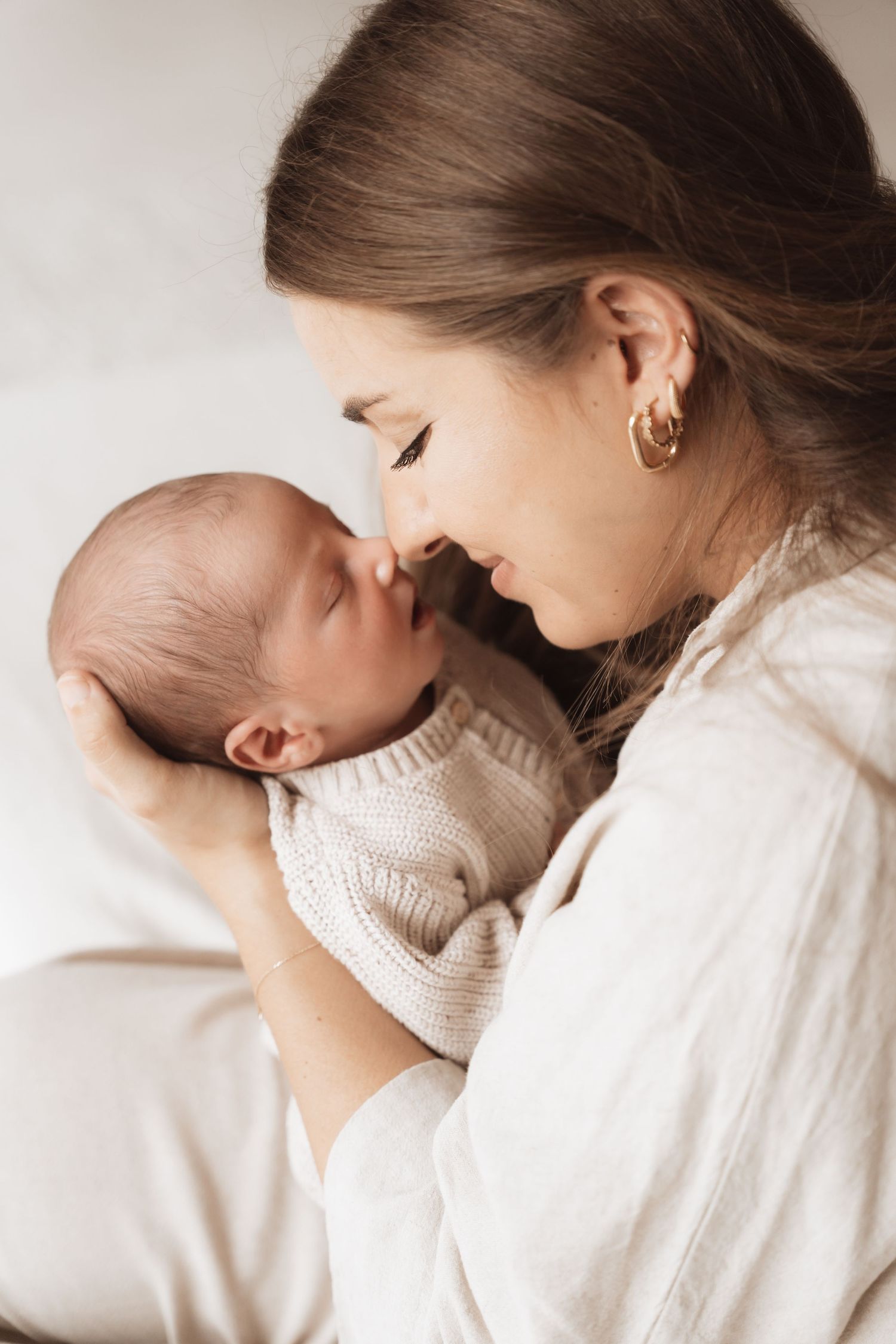 Intimate bonding moment between parent and baby in soft natural lighting.
