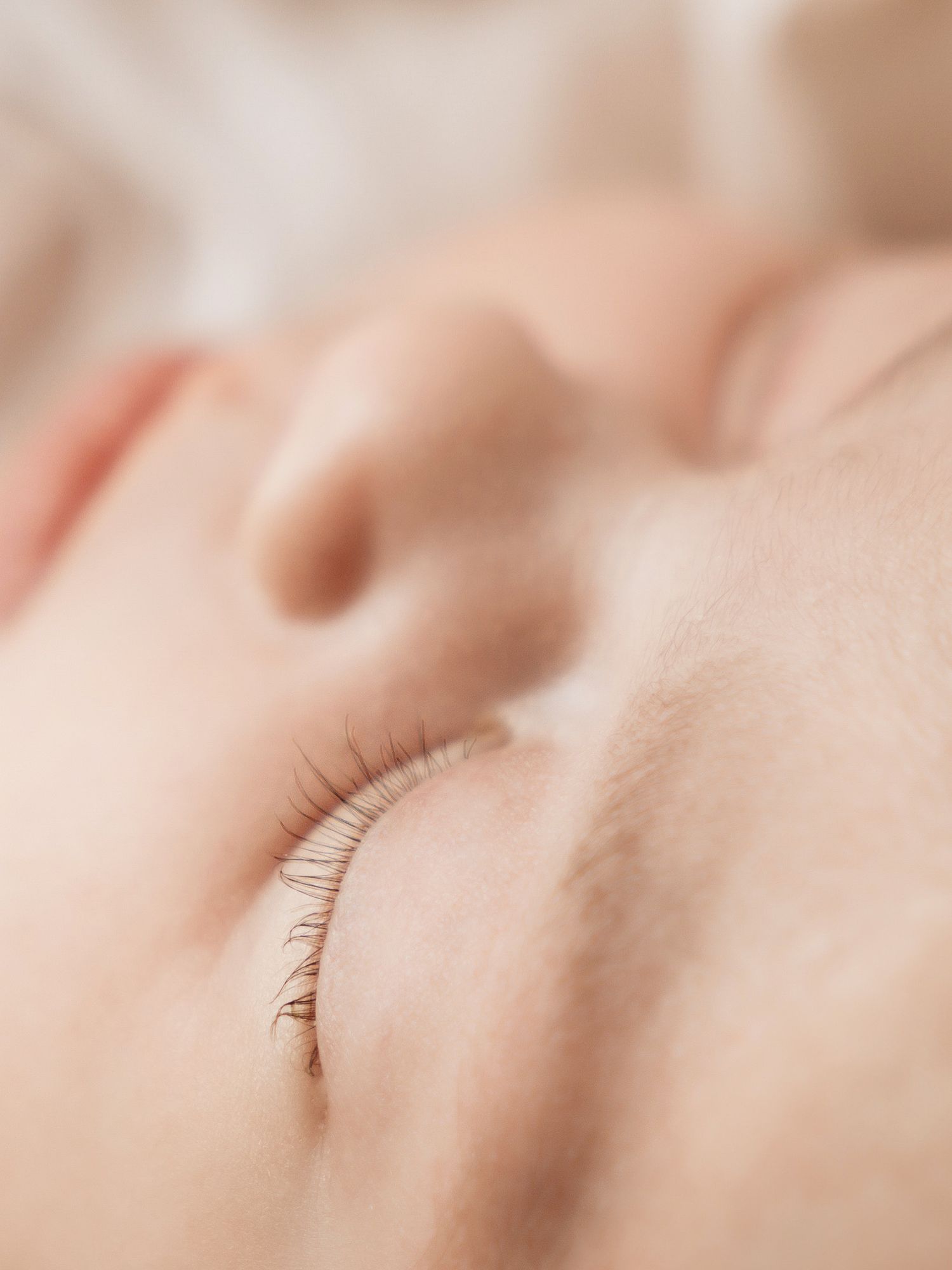 Close-up macro shot of delicate eyelashes in soft focus.